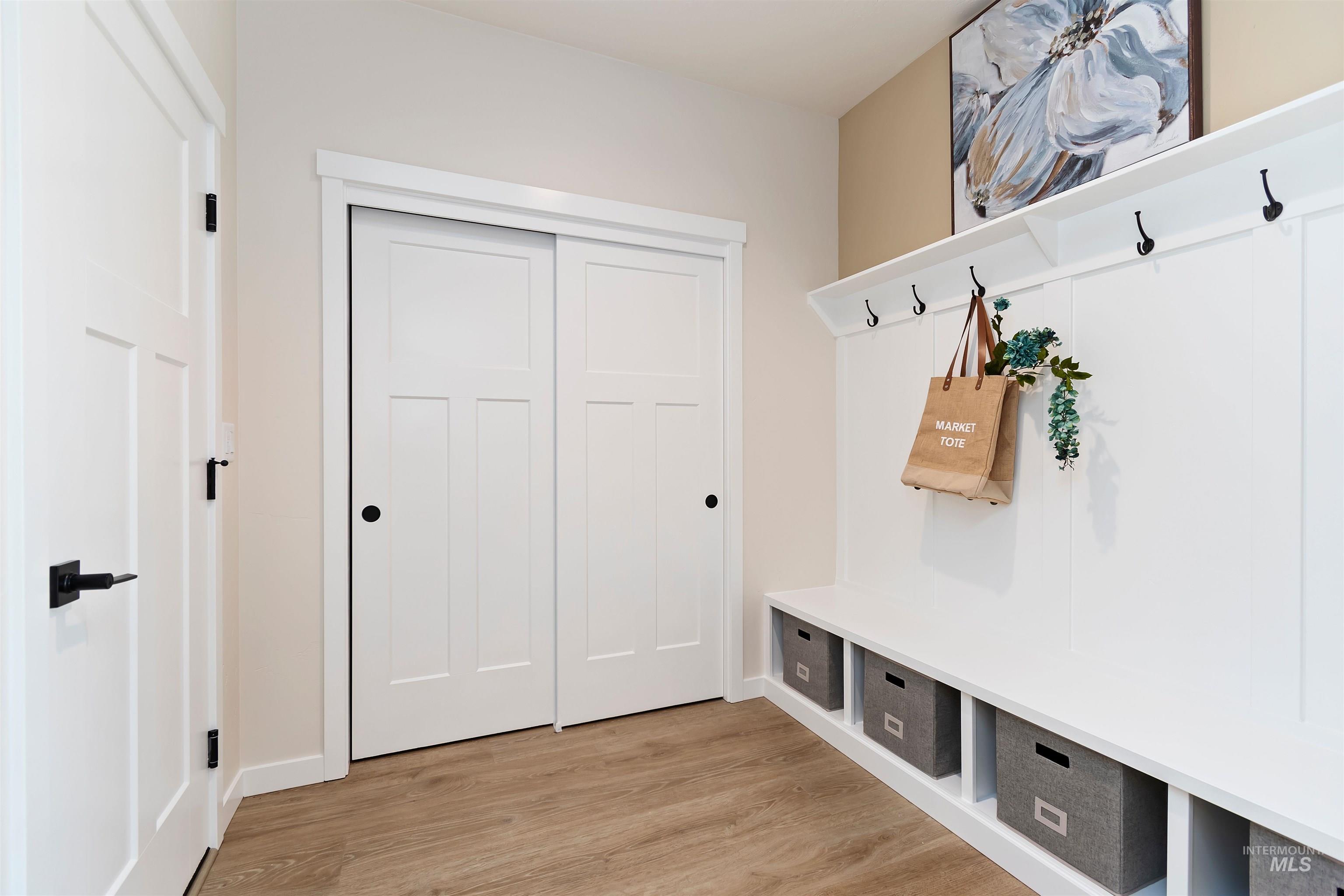 Mudroom featuring light wood finished floors and baseboards