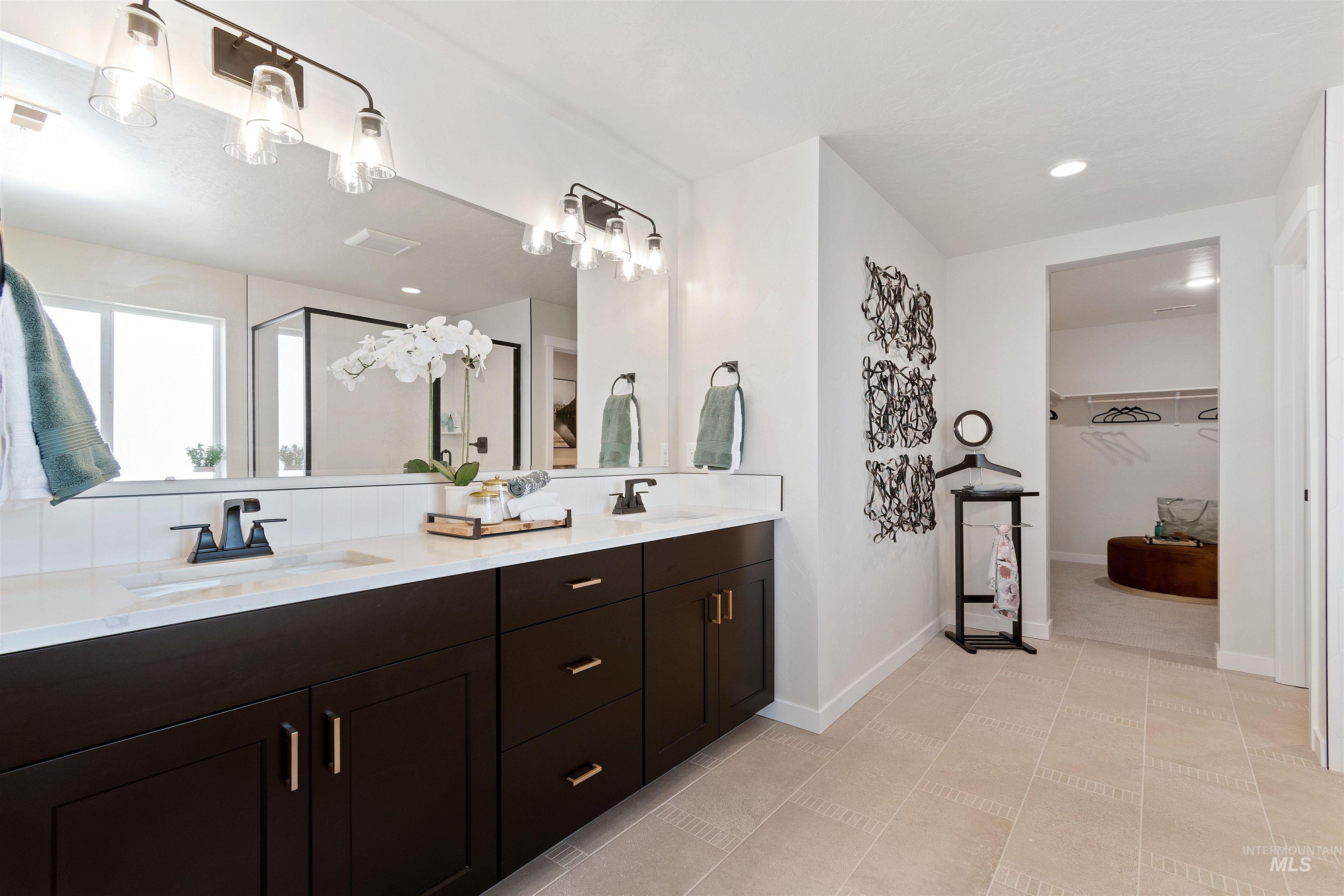 Full bathroom featuring a spacious closet, a stall shower, double vanity, and recessed lighting