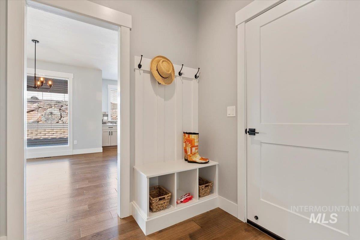 Mudroom with dark wood-type flooring and a chandelier