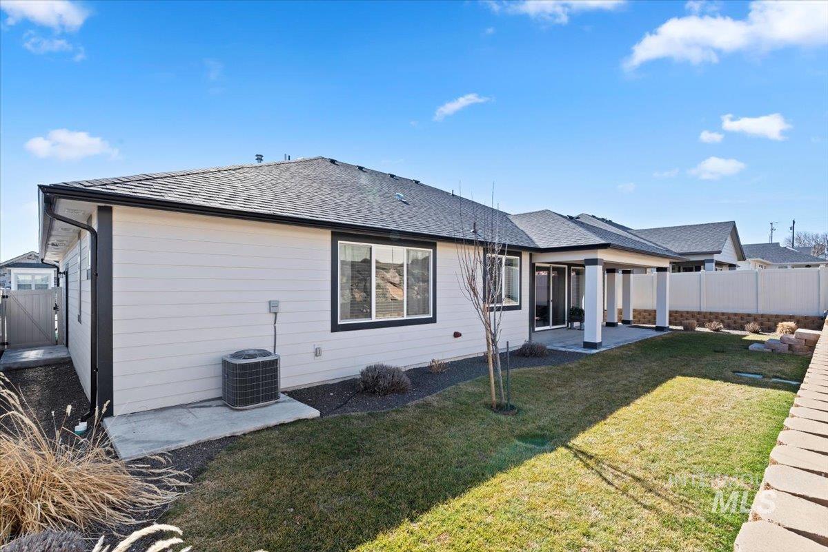 Back of house with a patio, roof with shingles, and a fenced backyard