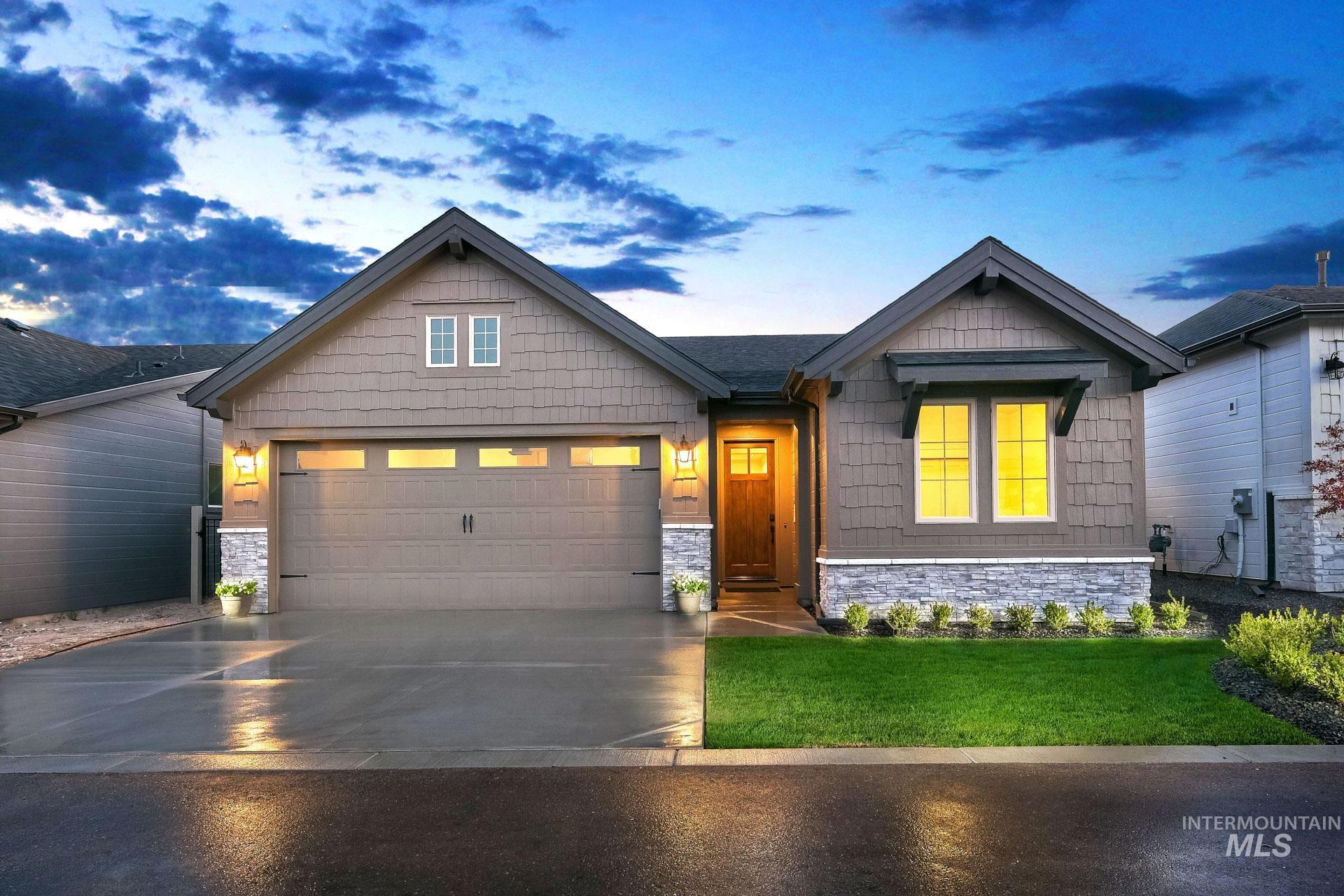 Craftsman-style home featuring stone siding, a front yard, and concrete driveway