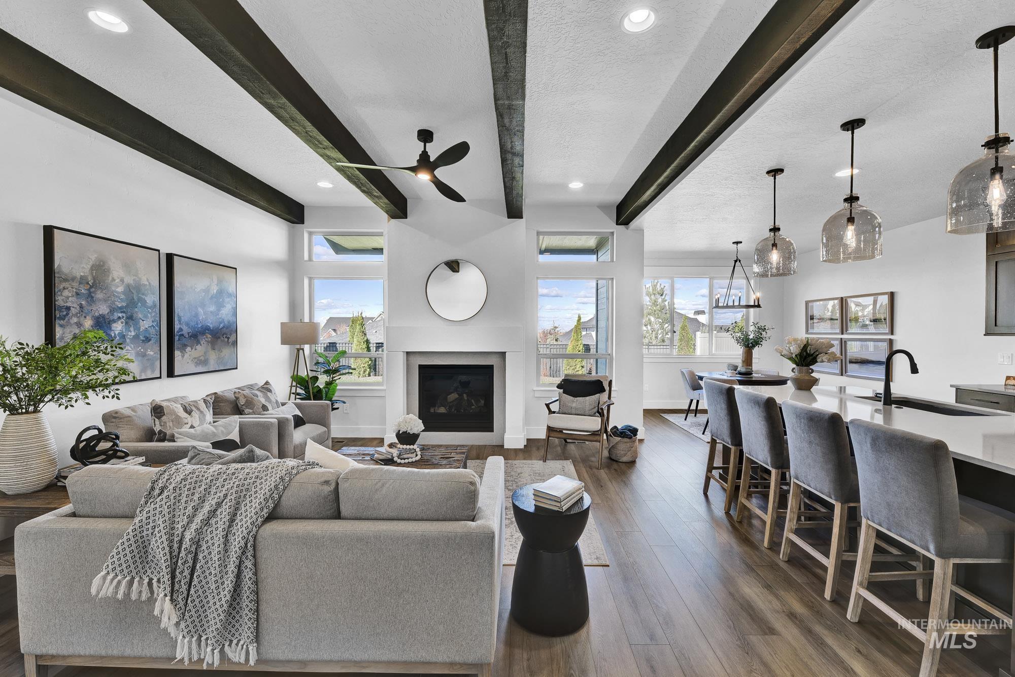 Living room with beamed ceiling, a fireplace, plenty of natural light, recessed lighting, and dark wood-style flooring