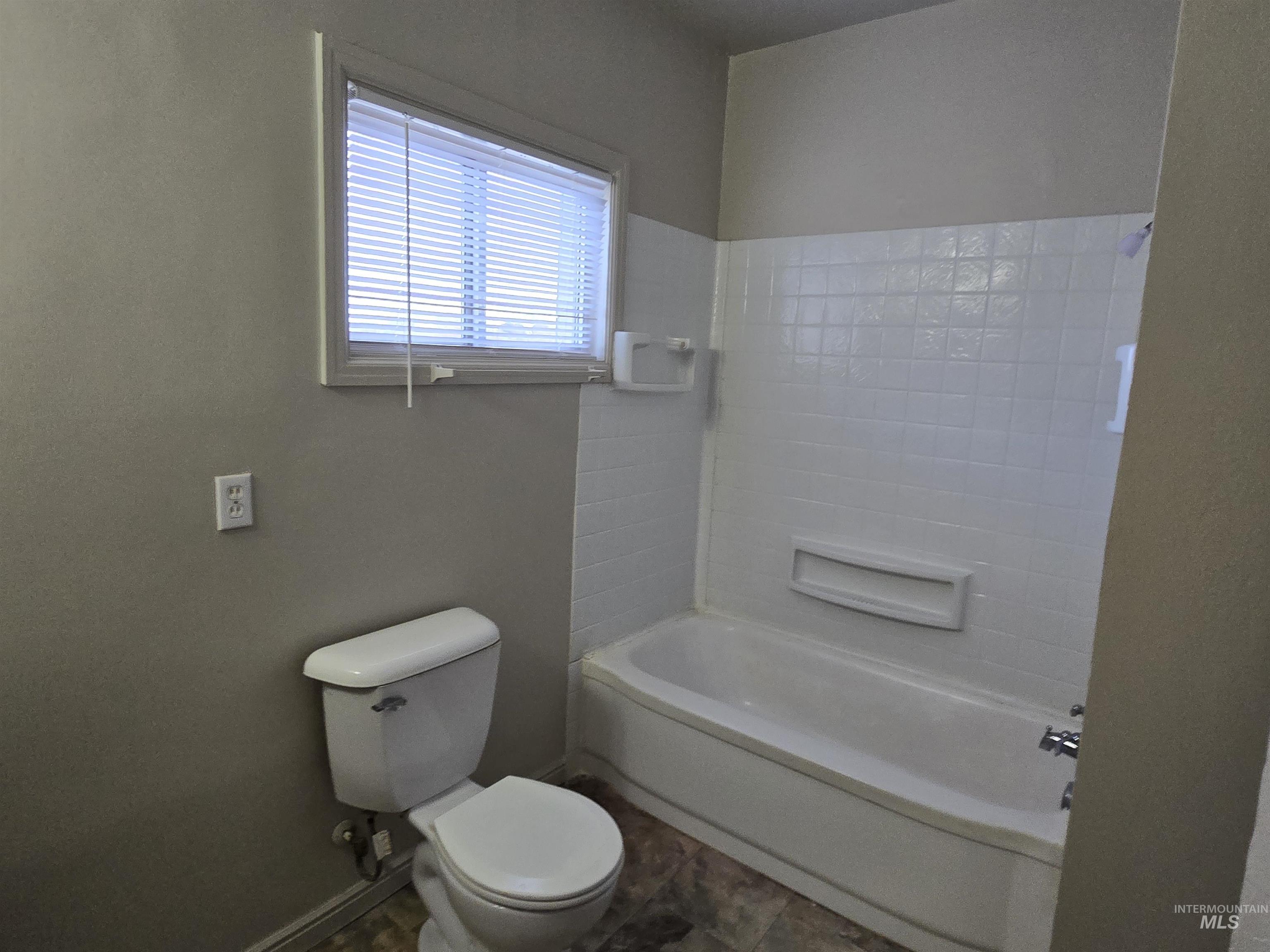 Full bathroom with toilet and baseboards