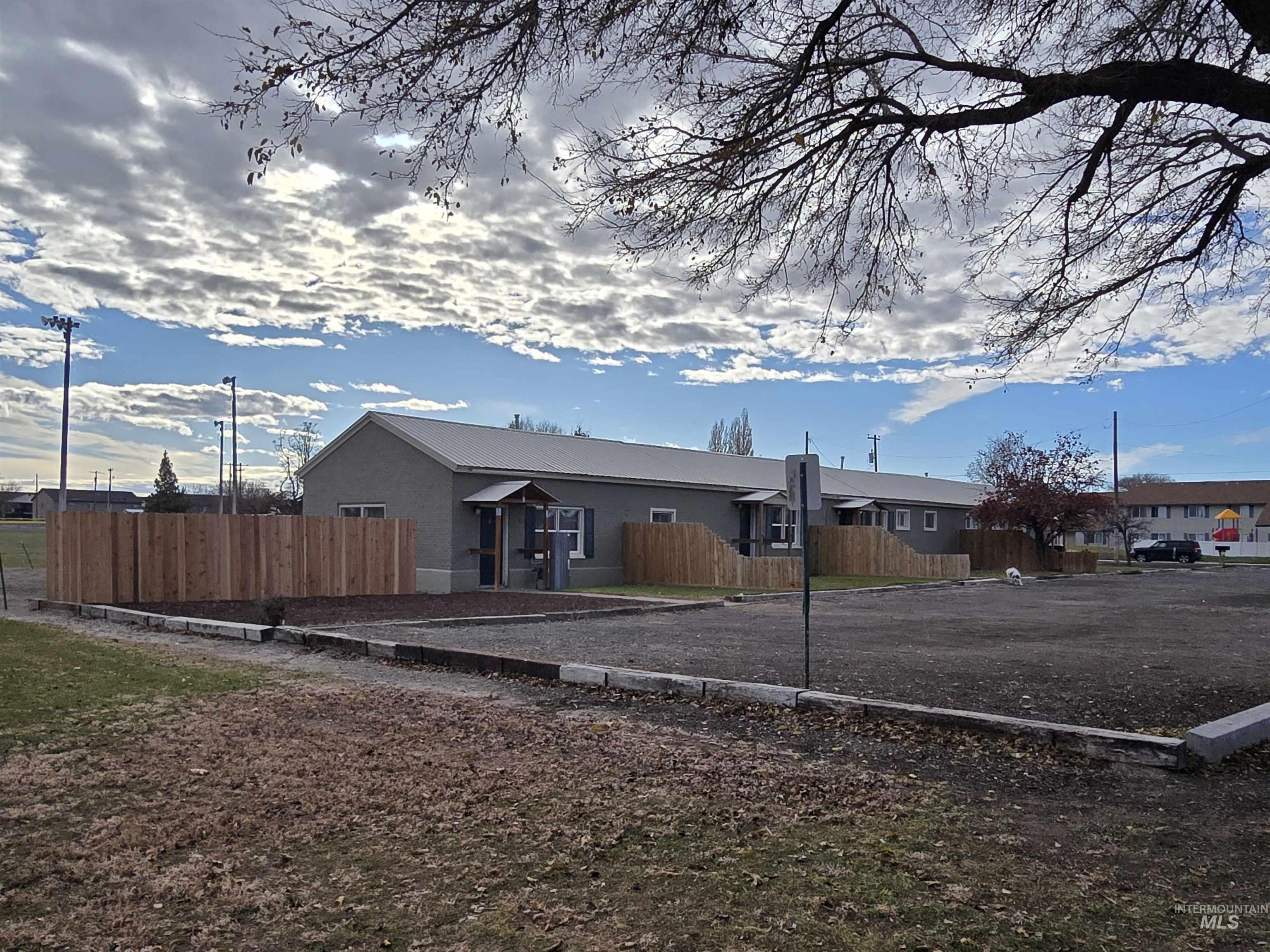 View of front facade with a fenced front yard and a metal roof
