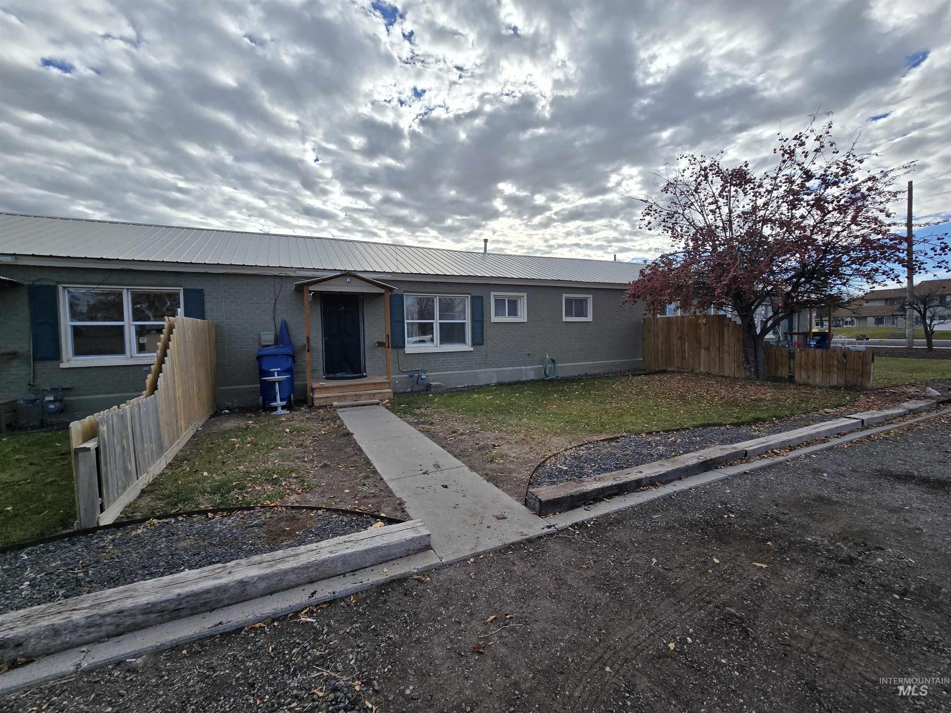 View of front of home with a metal roof and brick siding