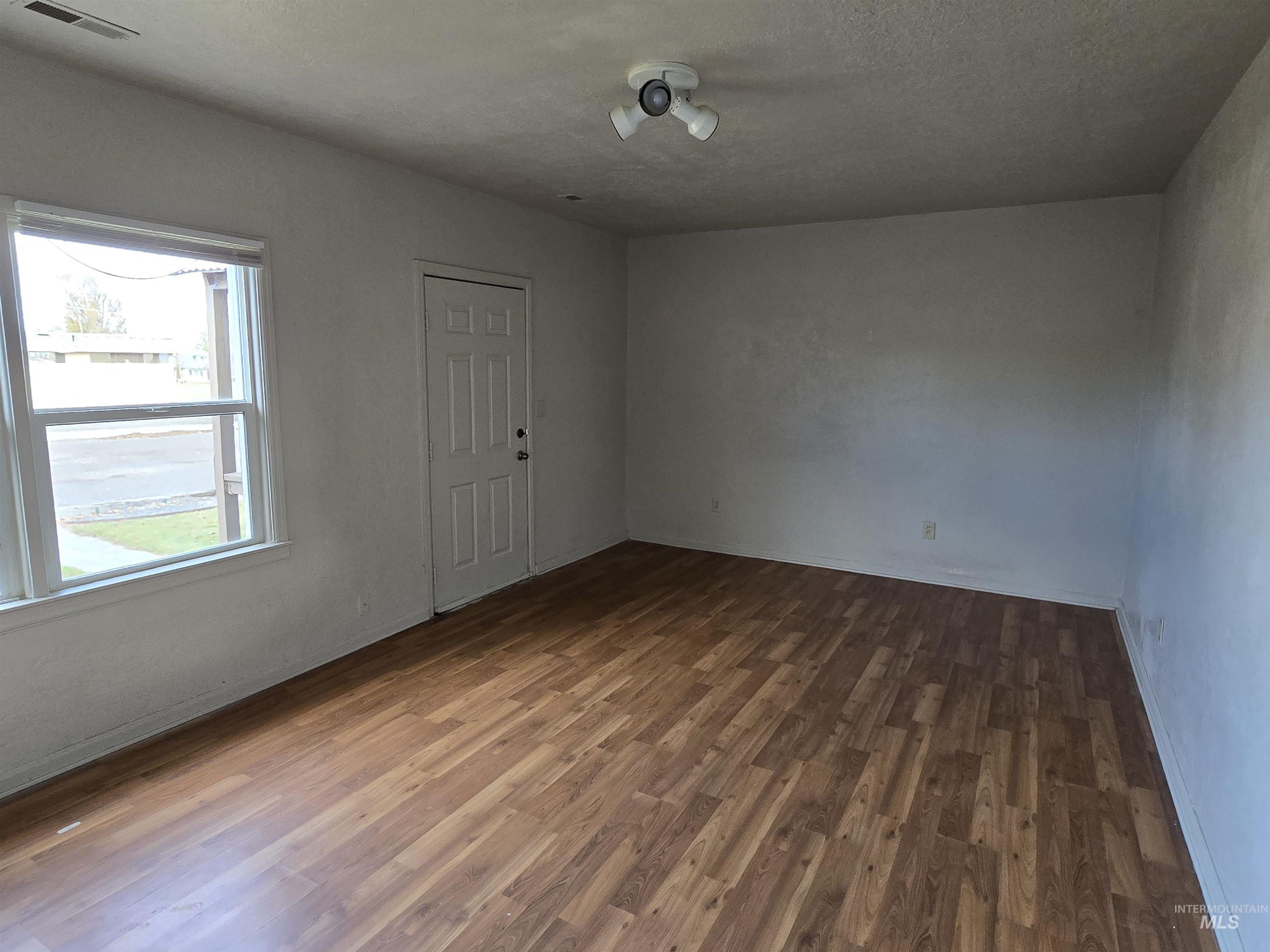 Spare room with wood finished floors and a textured ceiling
