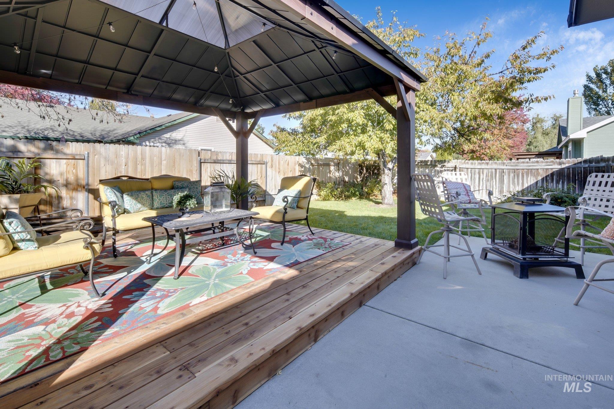 Wooden deck featuring a fenced backyard, an outdoor hangout area, a gazebo, and a patio area