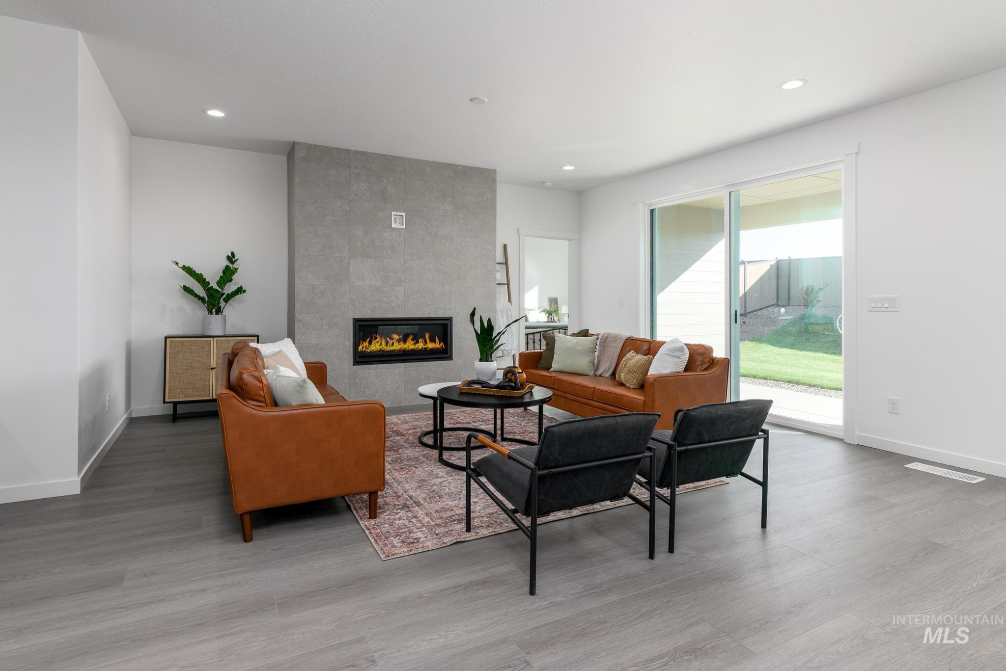Living area with a fireplace, recessed lighting, and light wood-style floors