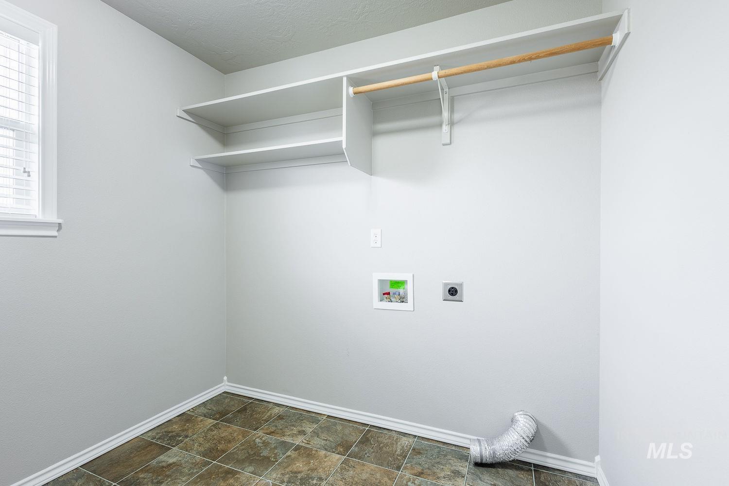 Washroom featuring stone finish floors, washer hookup, electric dryer hookup, and a textured ceiling