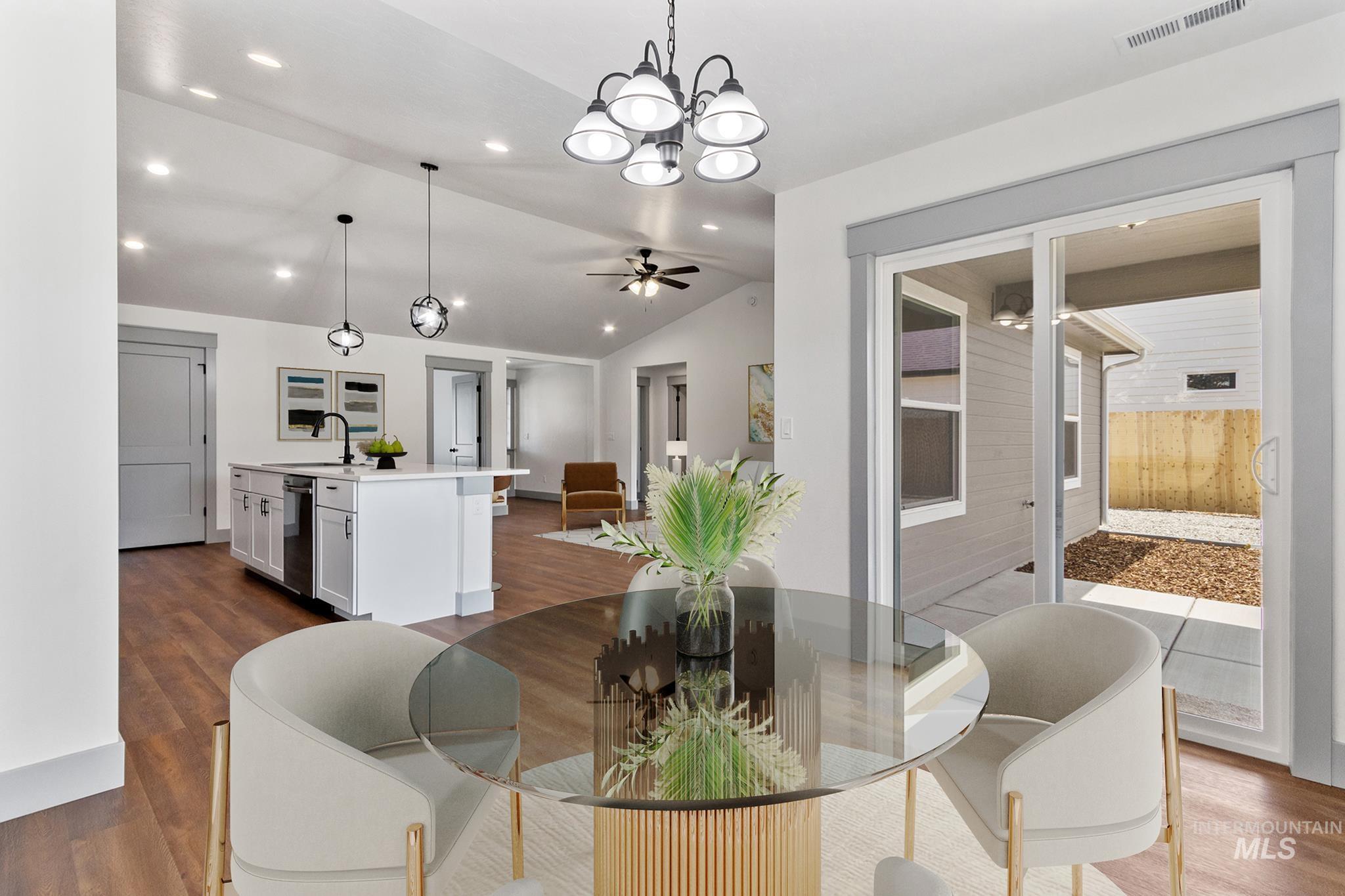 Dining area with dark wood finished floors, a chandelier, lofted ceiling, ceiling fan, and recessed lighting