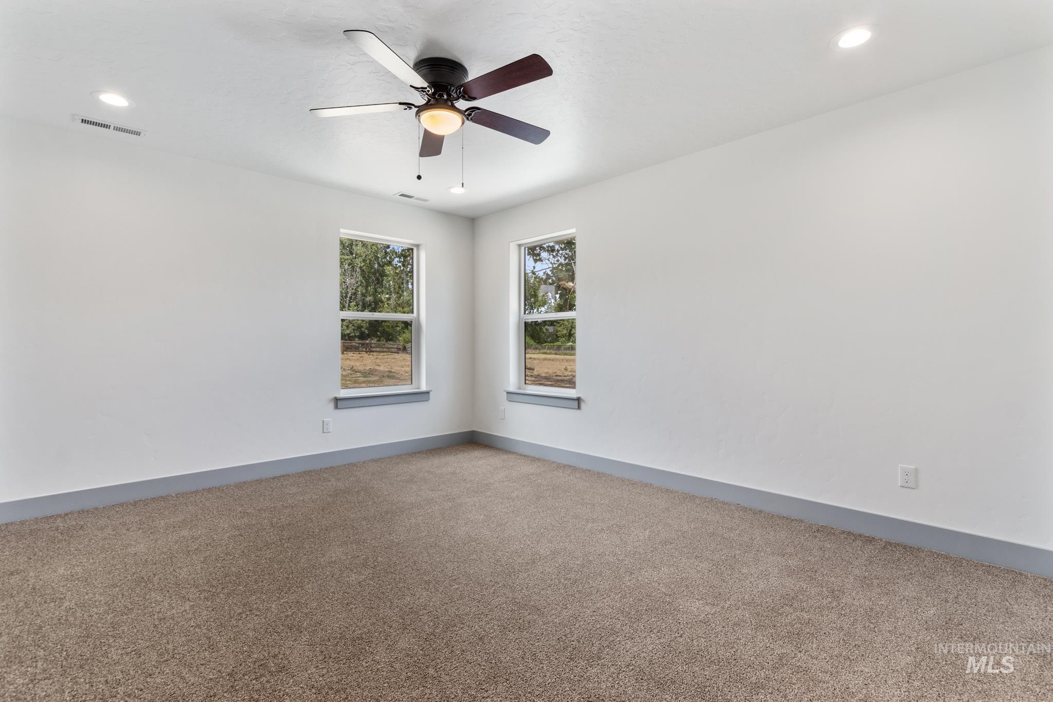 Empty room featuring carpet flooring, recessed lighting, and ceiling fan
