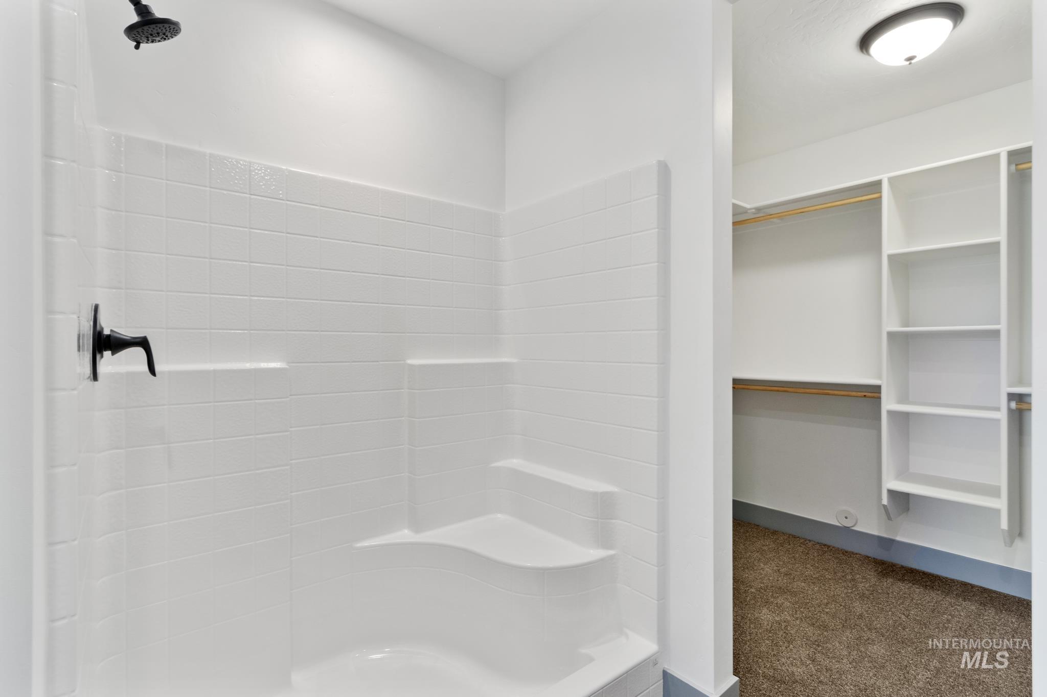 Full bathroom featuring dark colored carpet and a shower