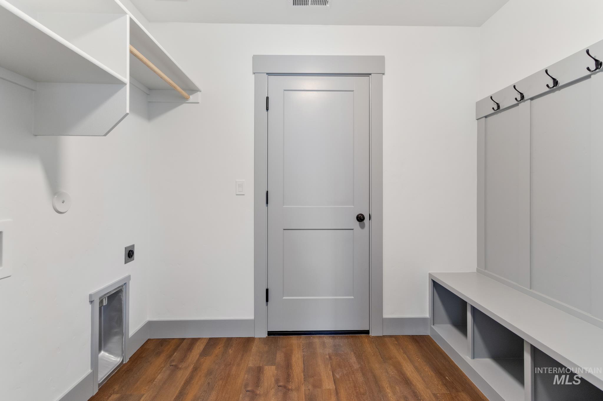 Laundry room with dark wood-type flooring and hookup for an electric dryer