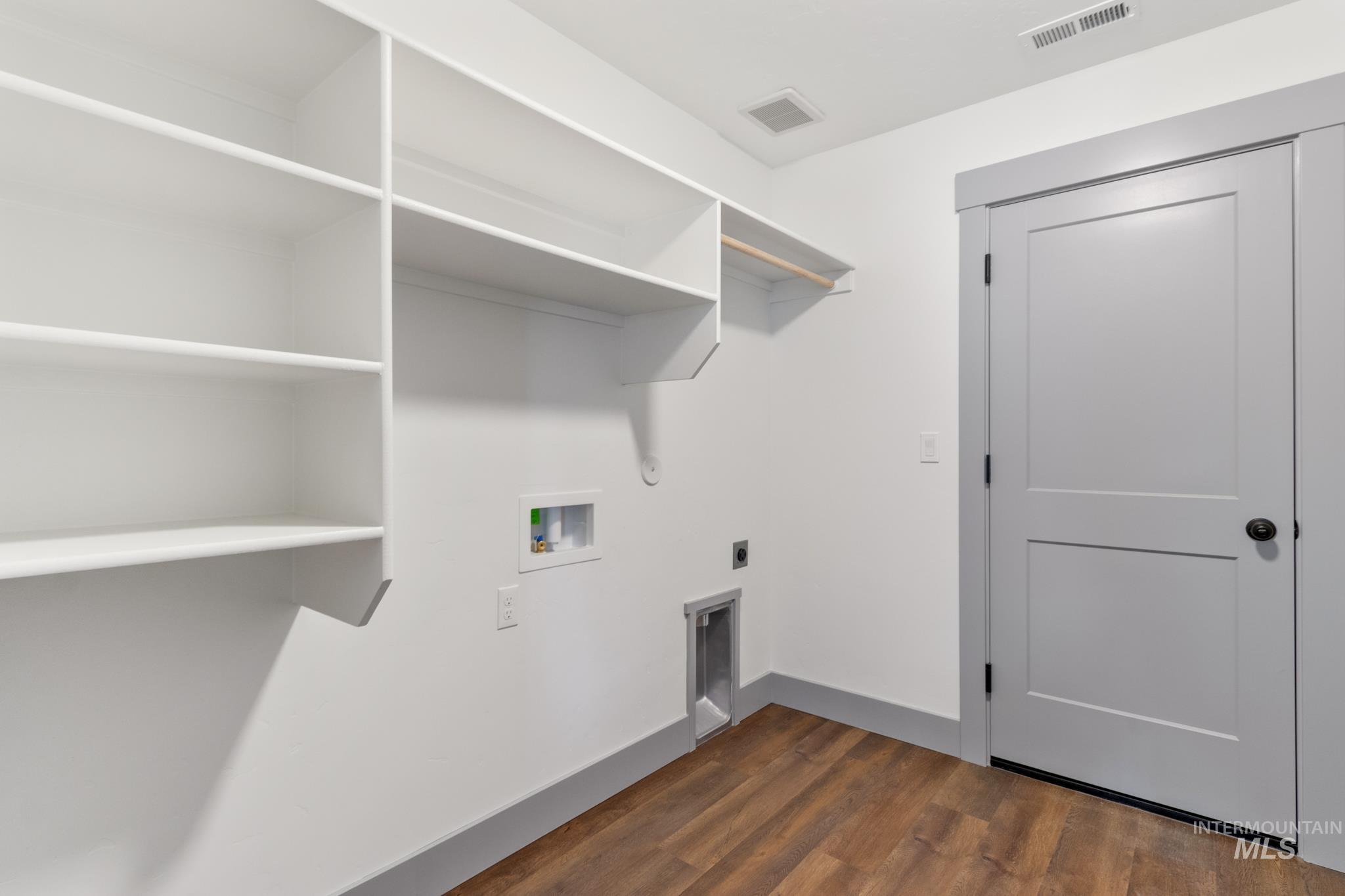Washroom featuring dark wood-type flooring, washer hookup, and hookup for an electric dryer