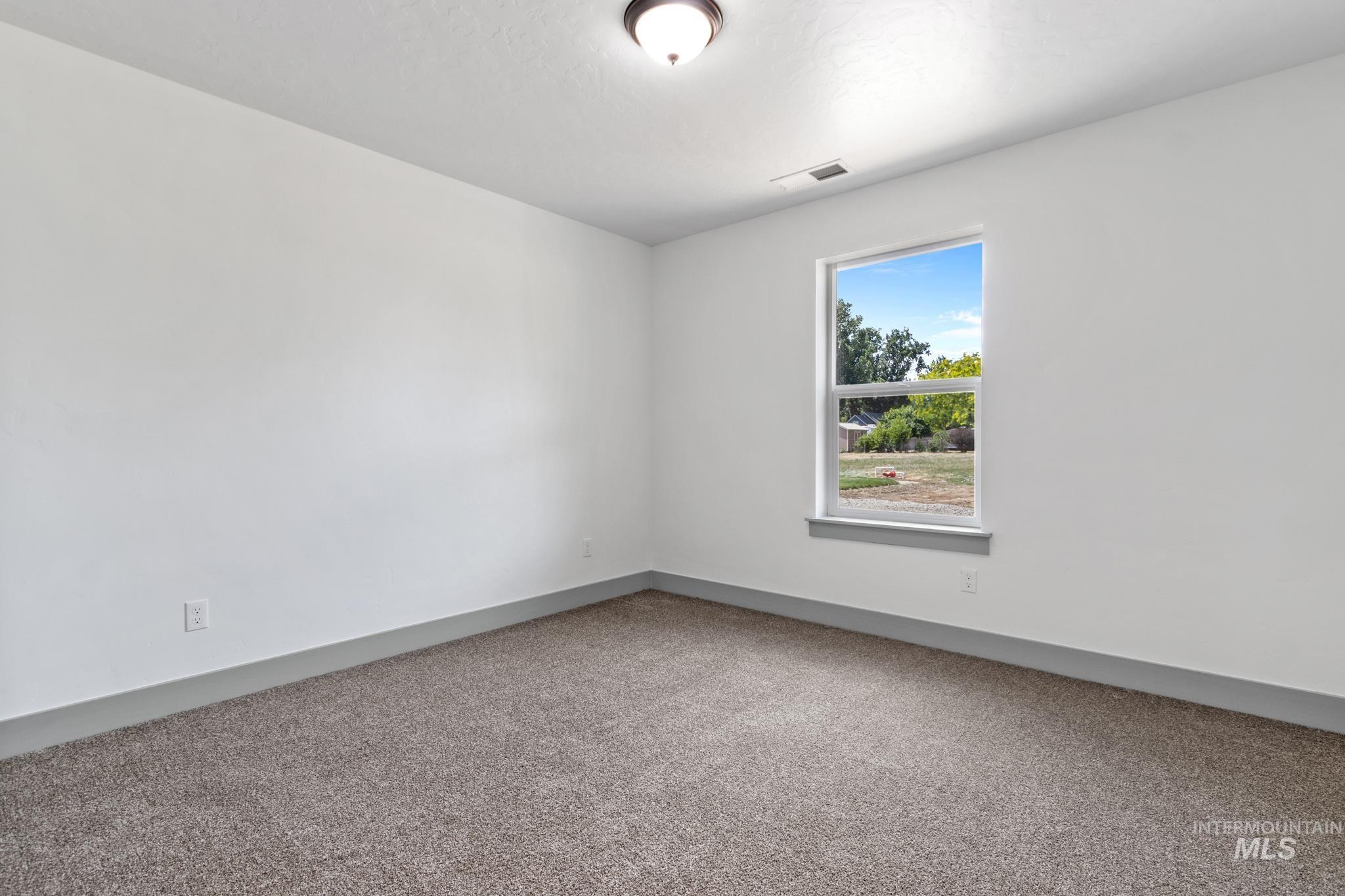 Carpeted empty room with baseboards