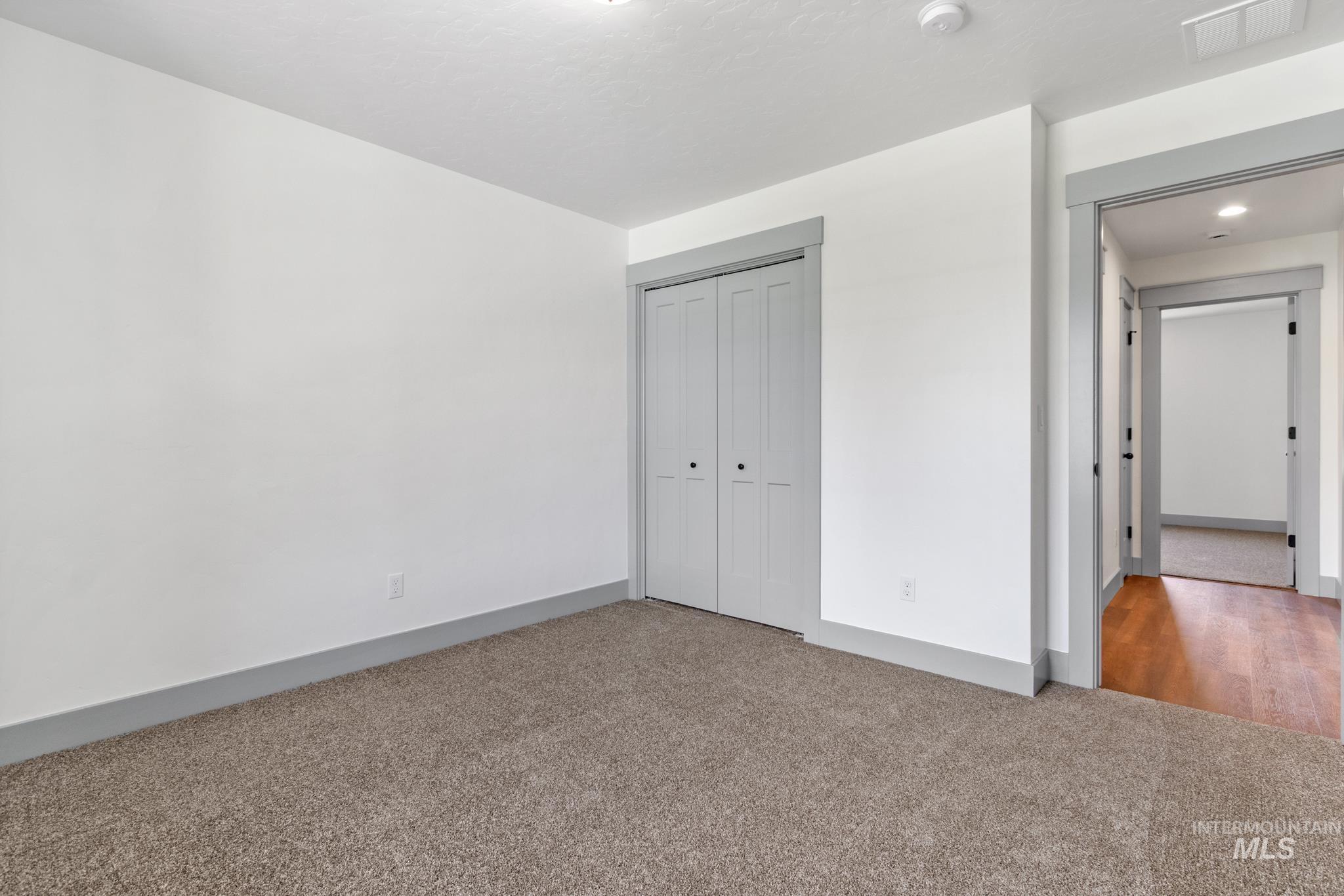 Unfurnished bedroom with carpet flooring and a closet