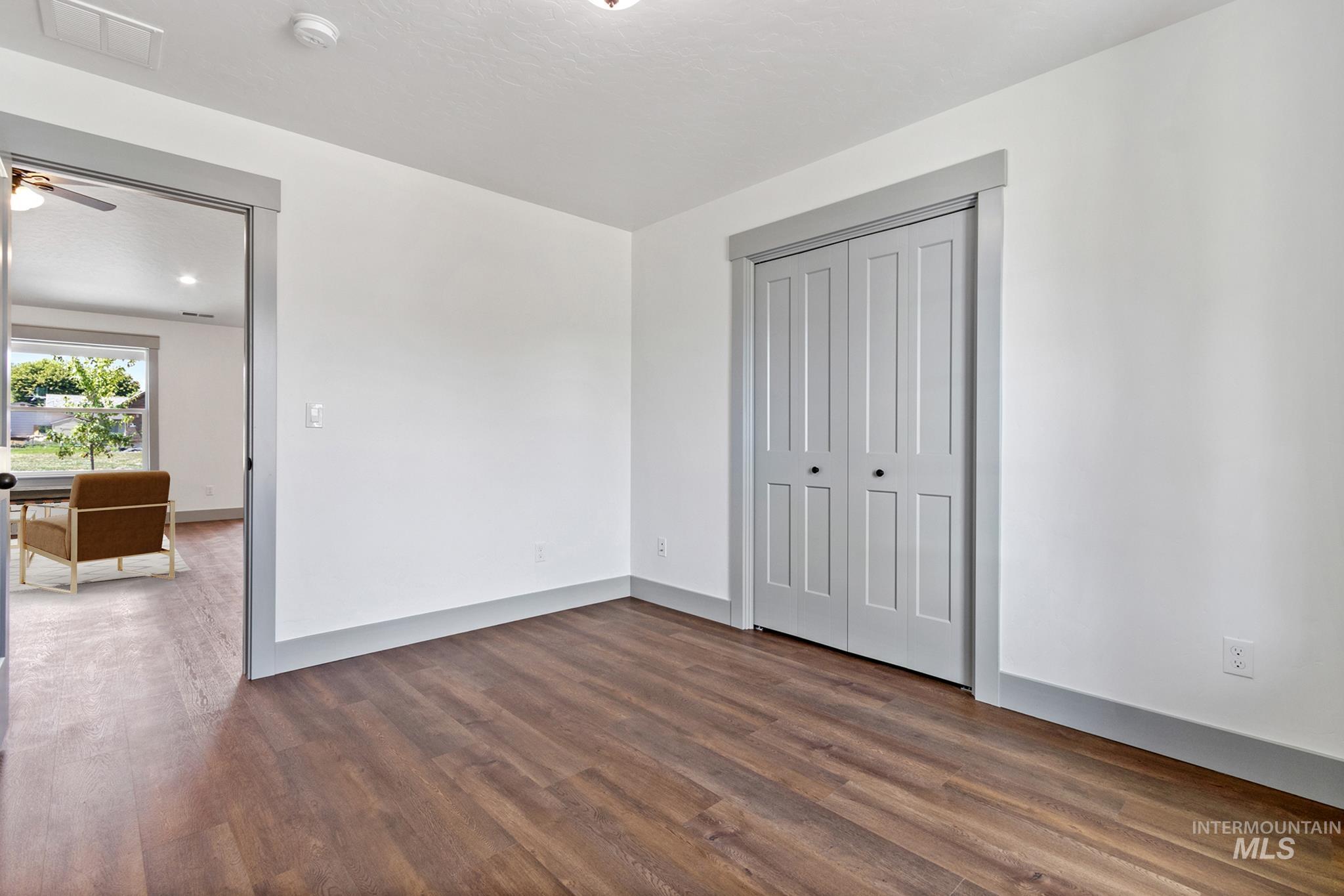 Unfurnished bedroom featuring dark wood-type flooring and a closet