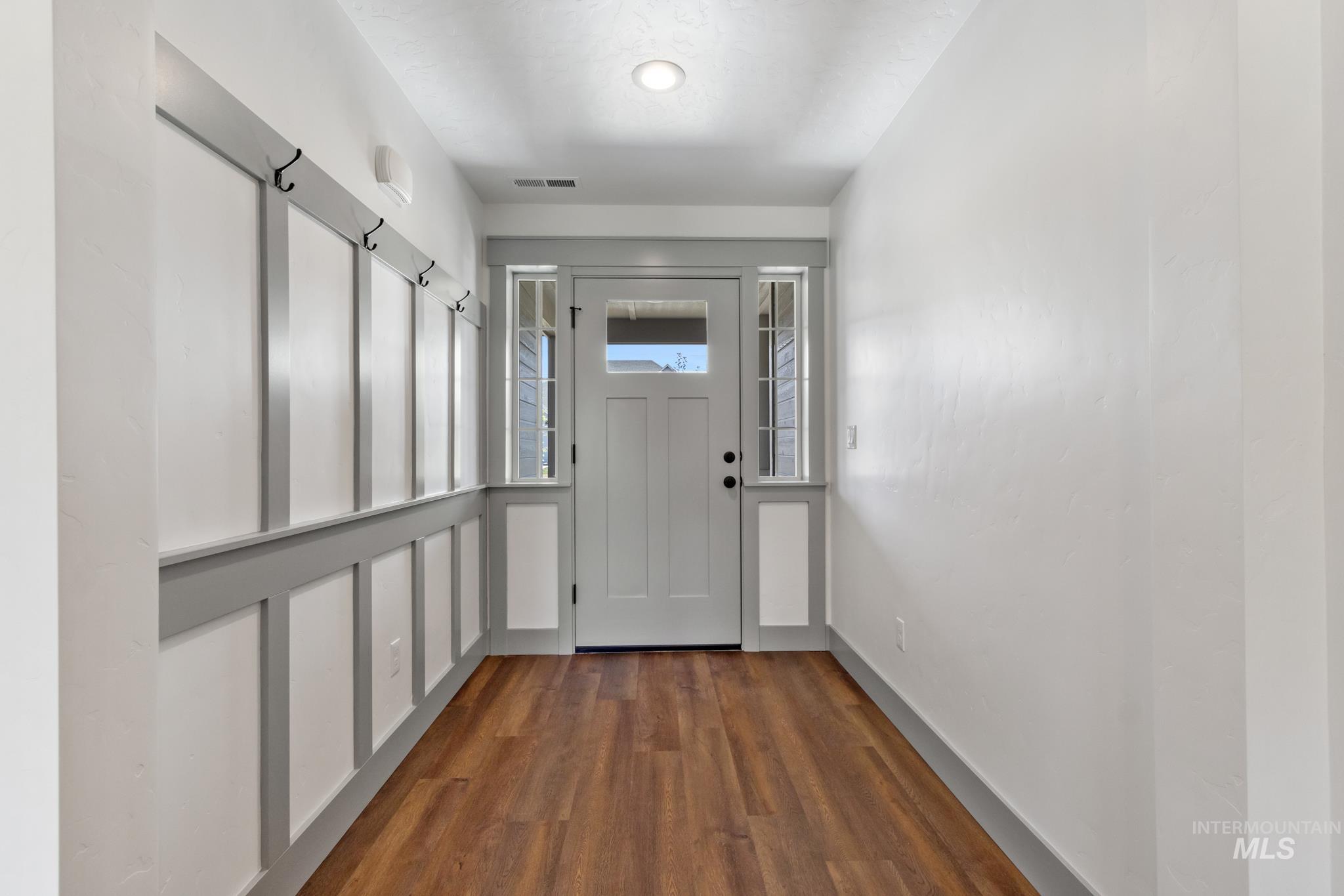 Doorway to outside with wood finished floors and baseboards