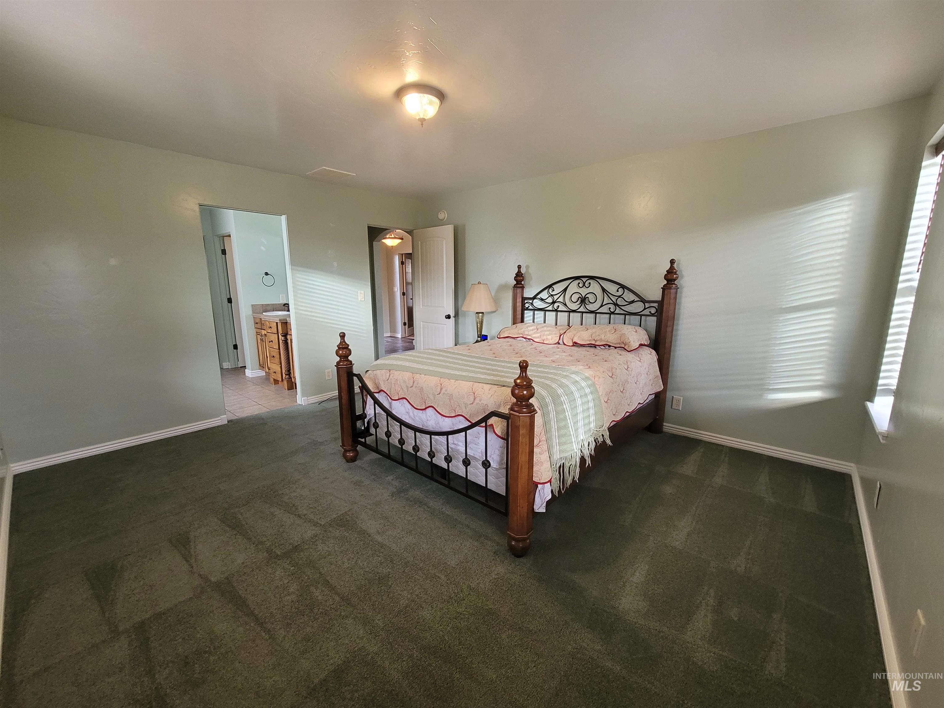 Bedroom featuring carpet flooring and ensuite bath