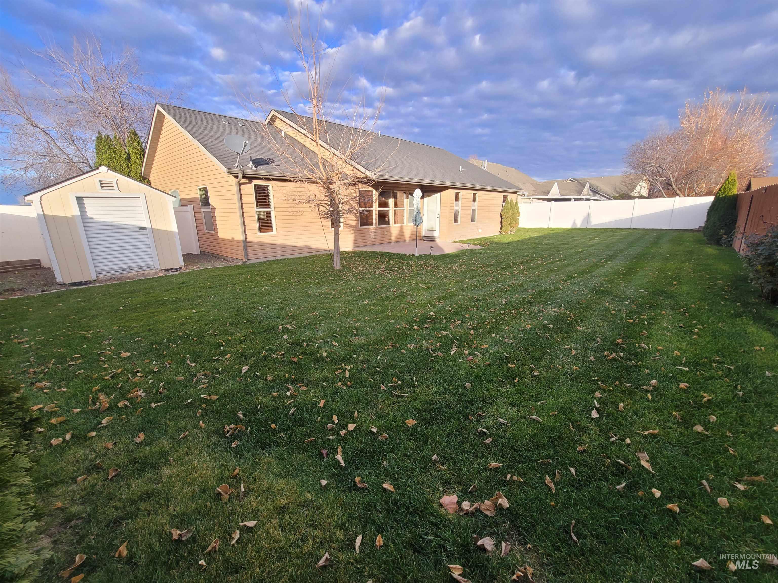 Rear view of house featuring a shed, a patio area, and a fenced backyard
