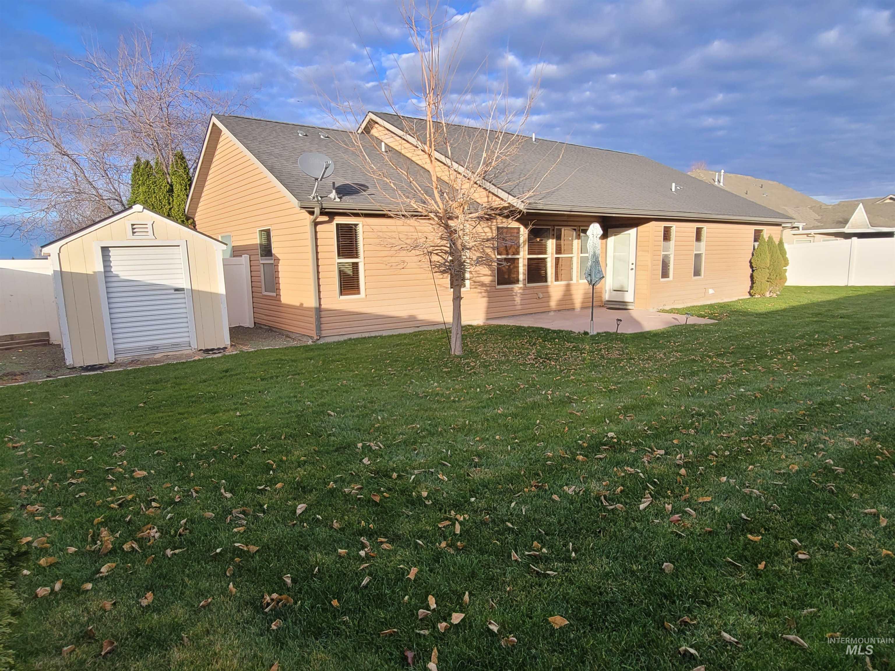 Rear view of house with a patio area and a storage shed
