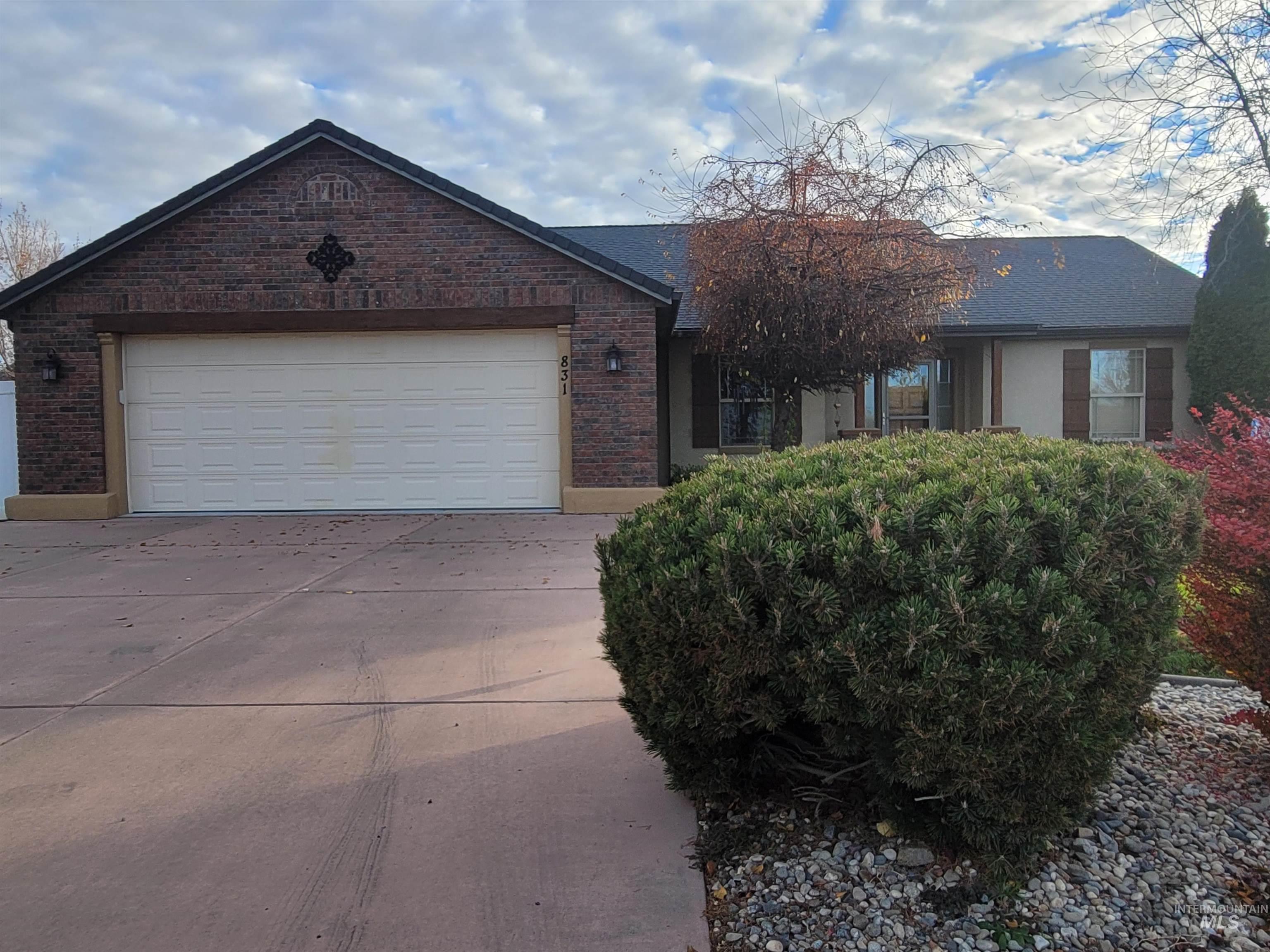 Ranch-style home with driveway, a garage, and brick siding