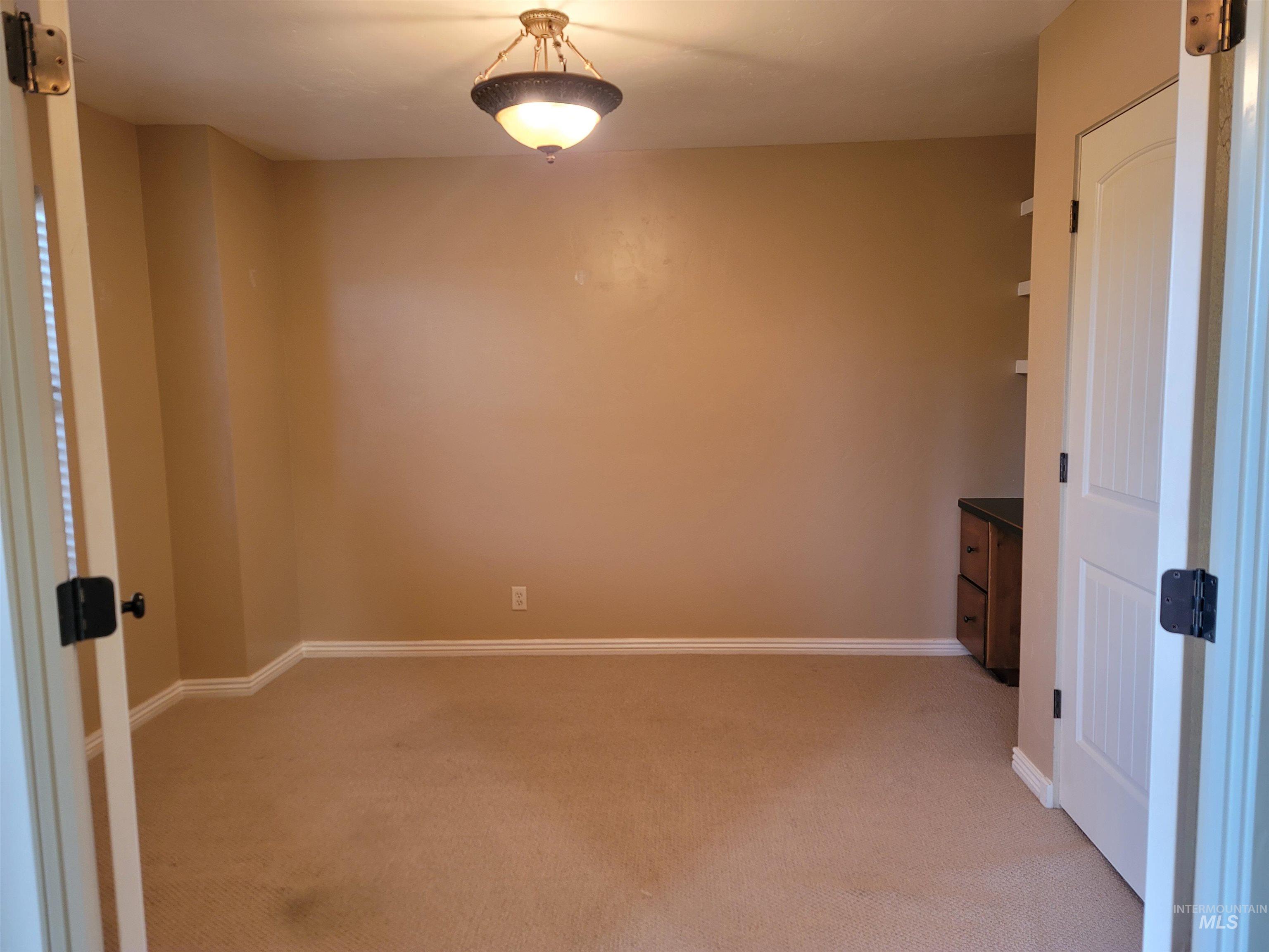 Spare room featuring baseboards and light carpet