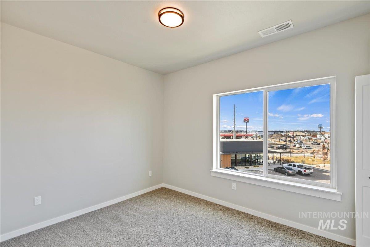 Spare room featuring carpet floors and baseboards