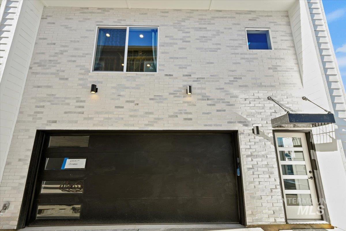 View of front of home featuring a garage and brick siding
