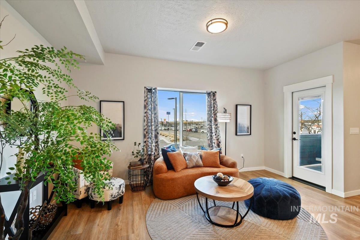 Living area featuring light wood-style flooring and a textured ceiling