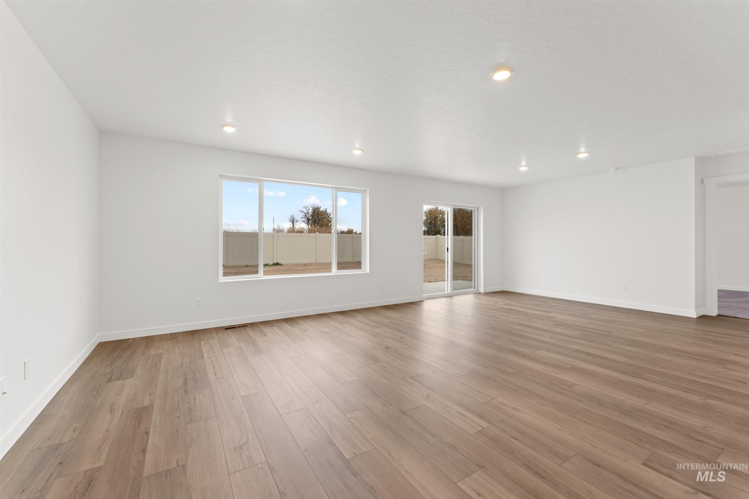 Empty room featuring light wood-type flooring and recessed lighting