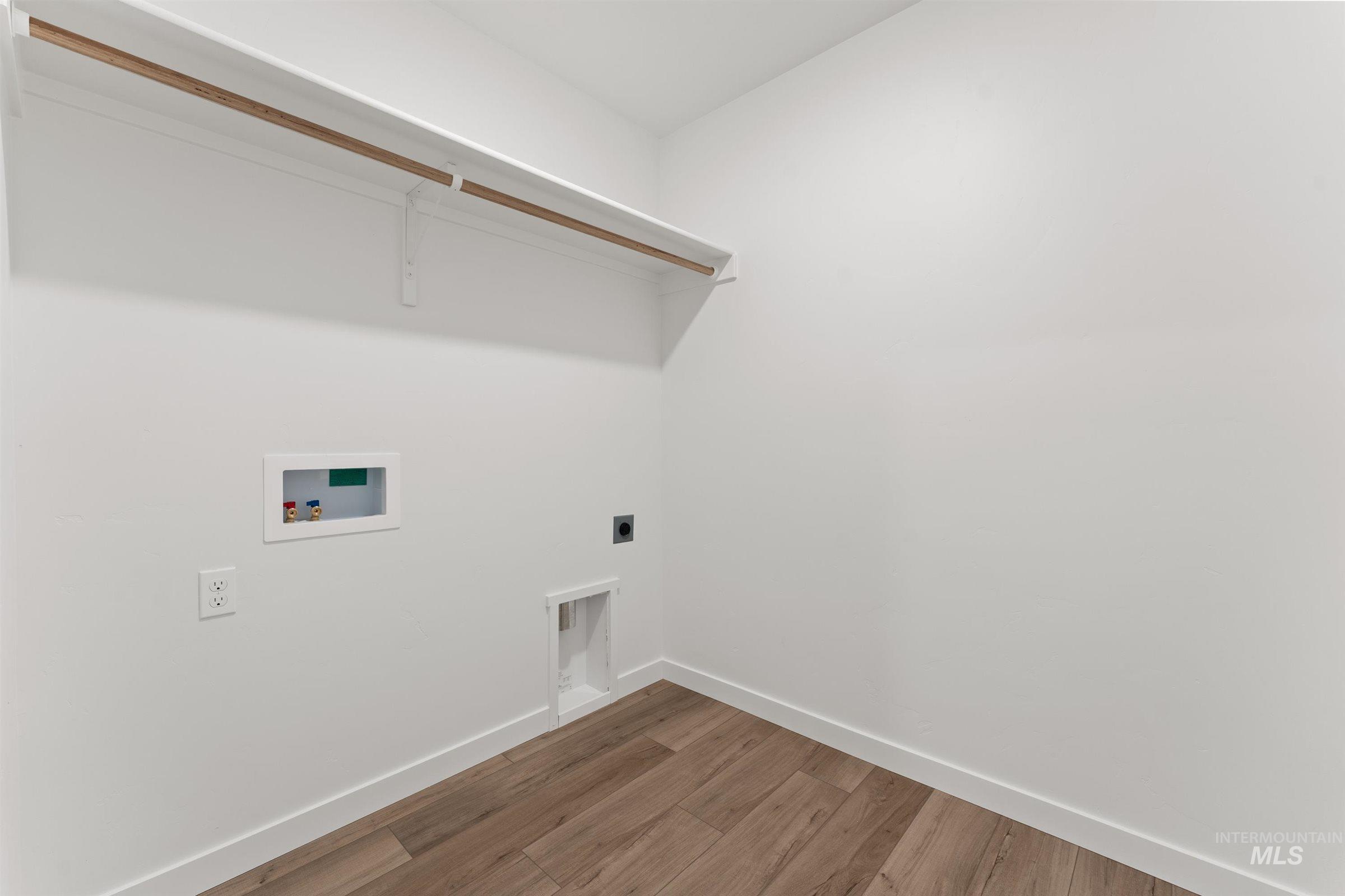 Washroom with light wood finished floors, electric dryer hookup, and hookup for a washing machine