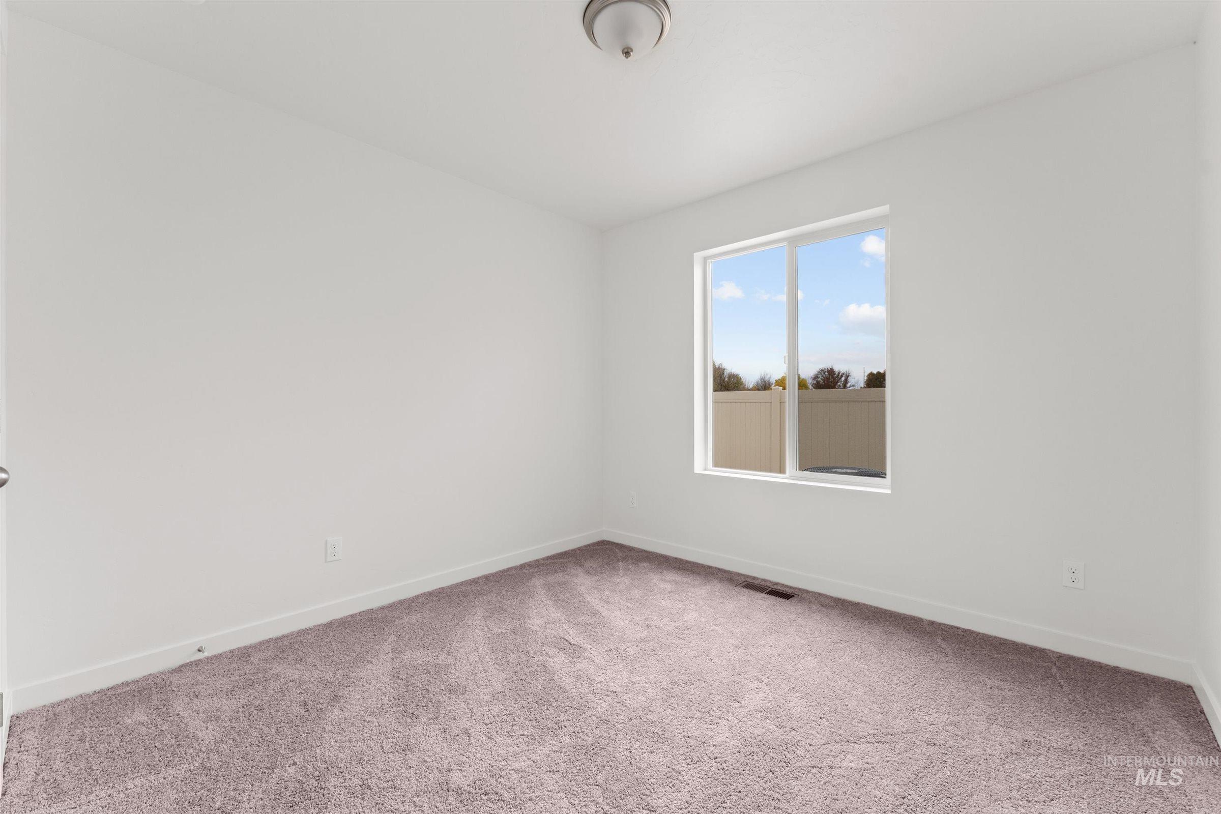 Carpeted empty room featuring baseboards