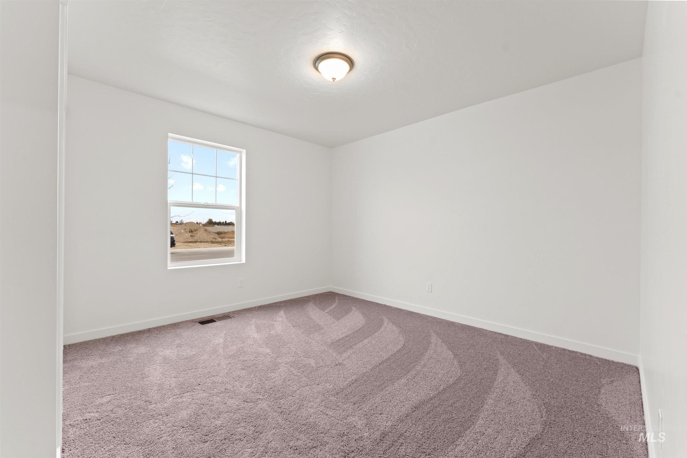 Carpeted empty room with baseboards
