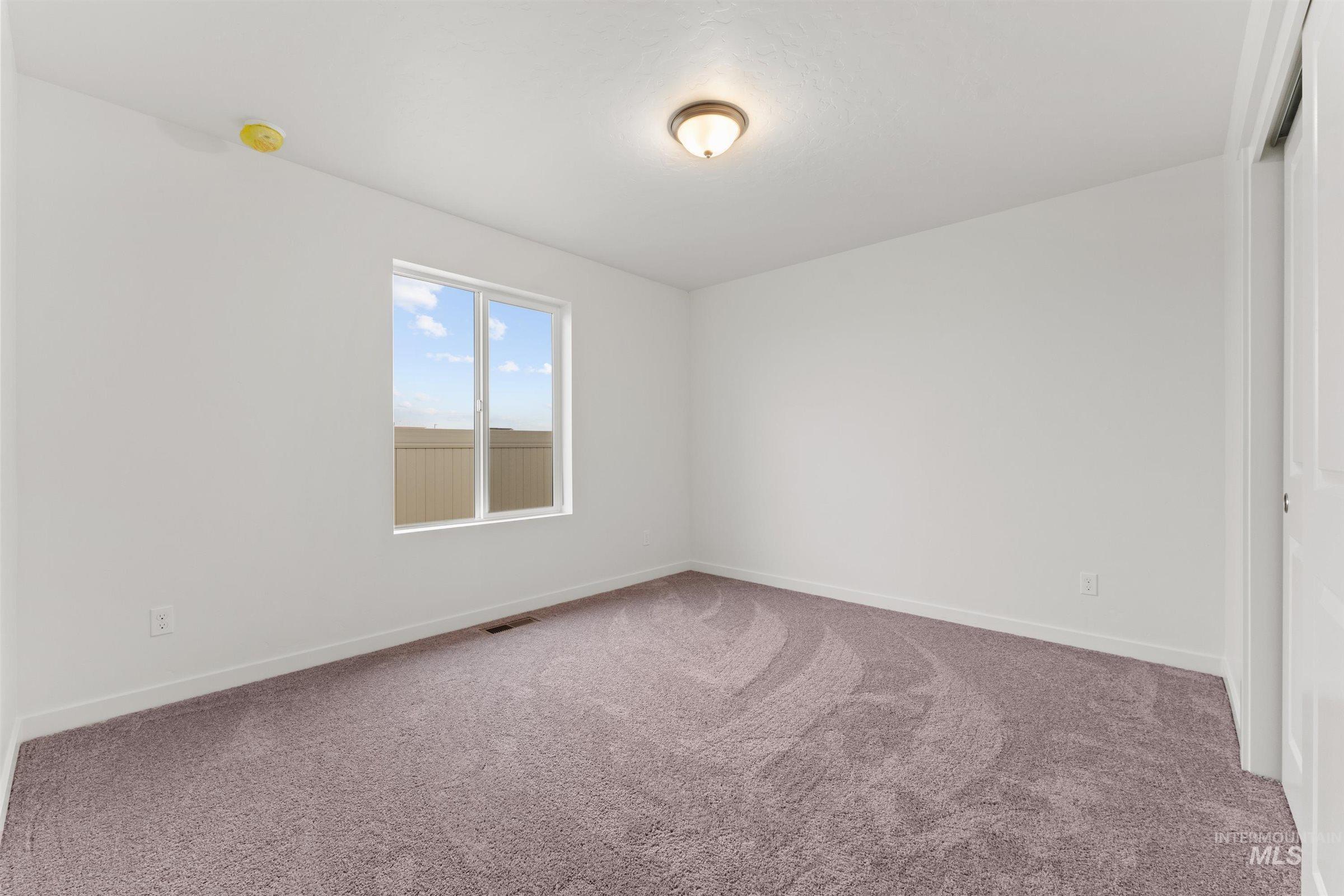 Carpeted empty room featuring baseboards