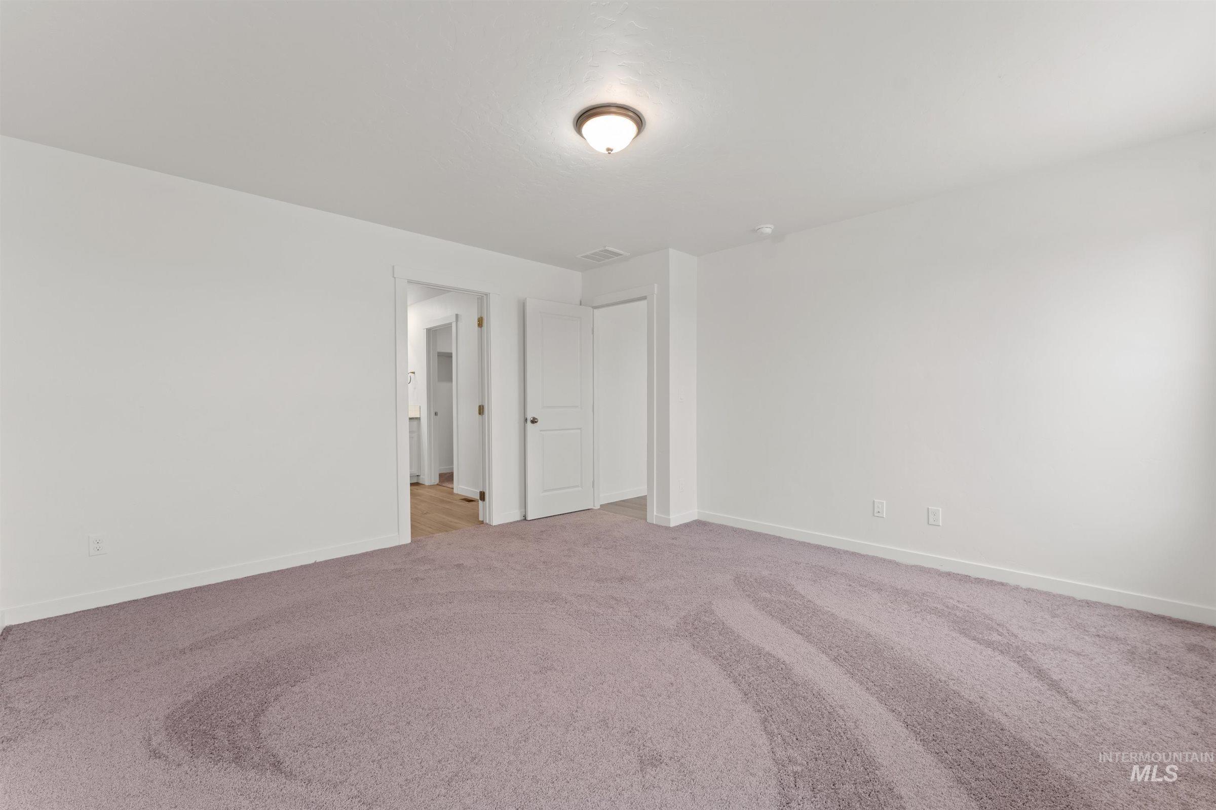 Unfurnished room with light colored carpet and baseboards