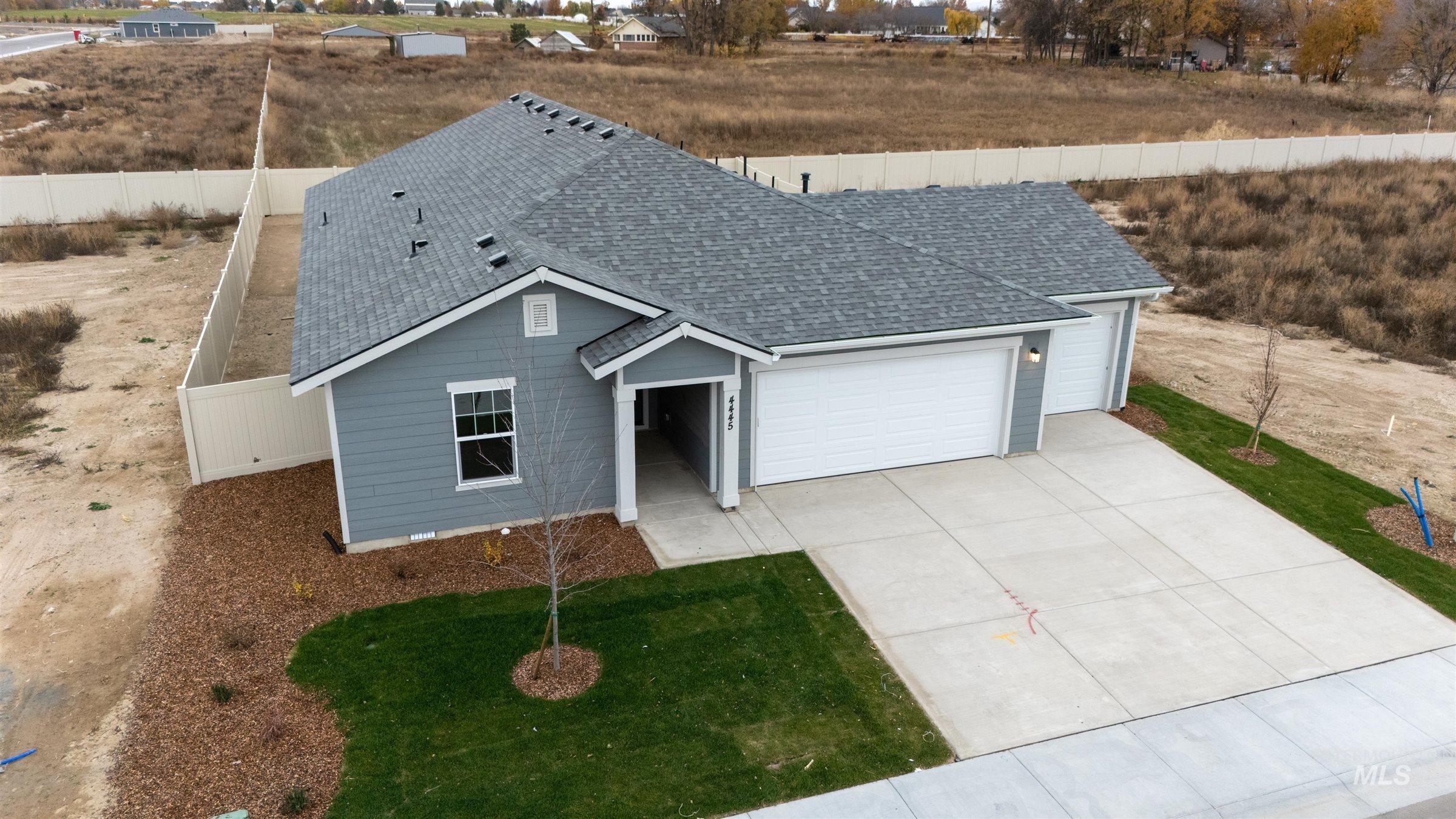 Ranch-style house with a shingled roof, a garage, and concrete driveway