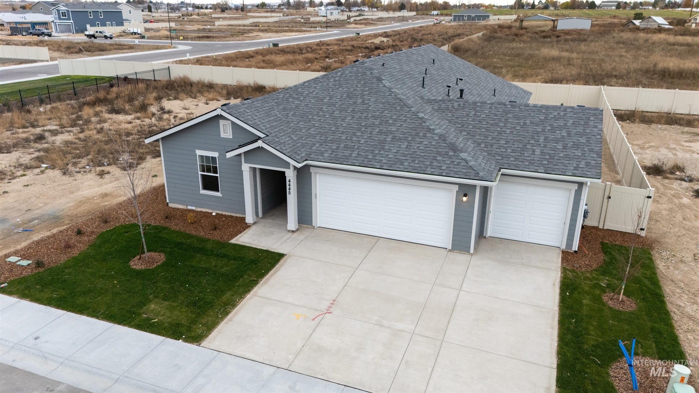 Single story home with roof with shingles, an attached garage, and concrete driveway