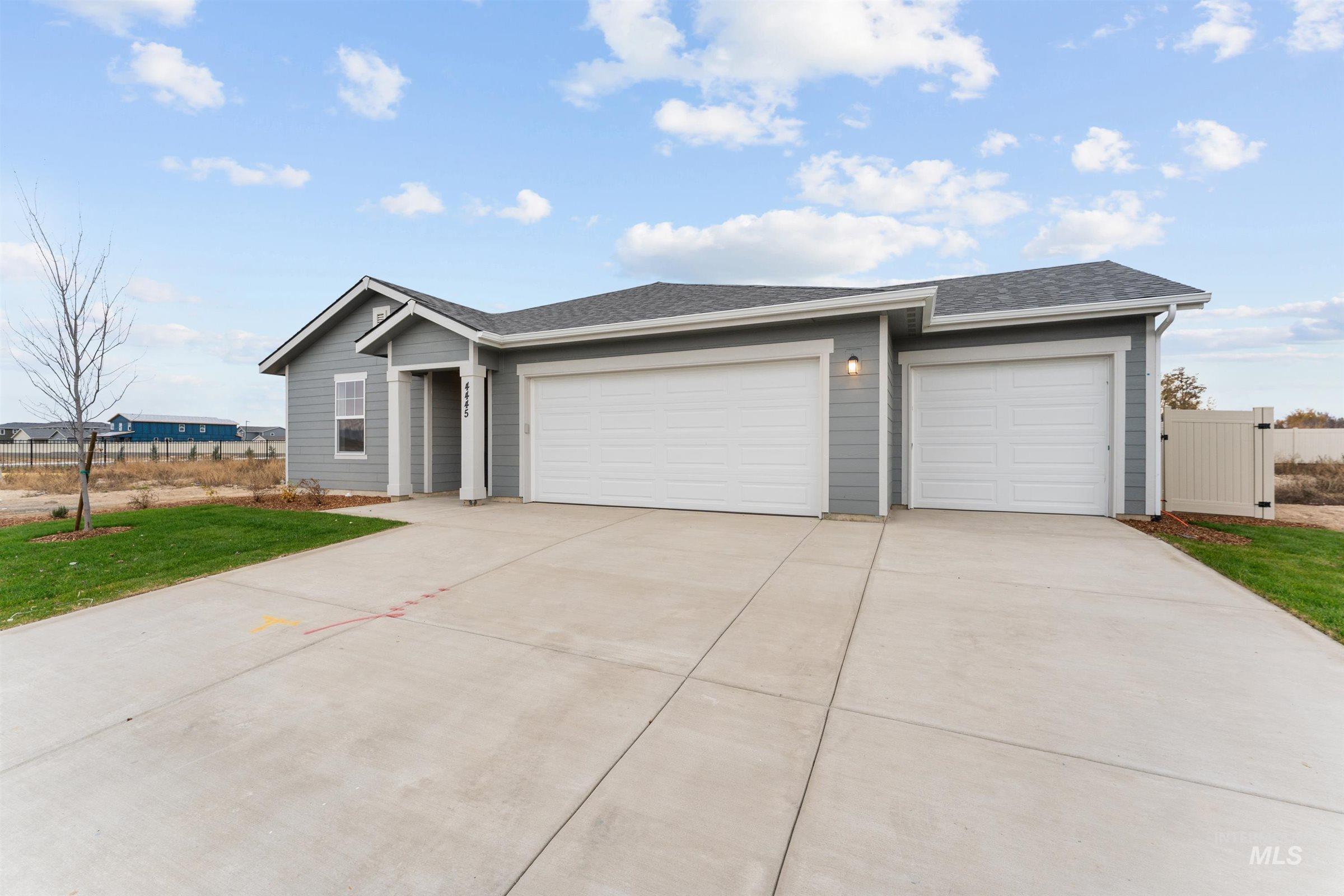 Ranch-style home with concrete driveway, an attached garage, and a shingled roof
