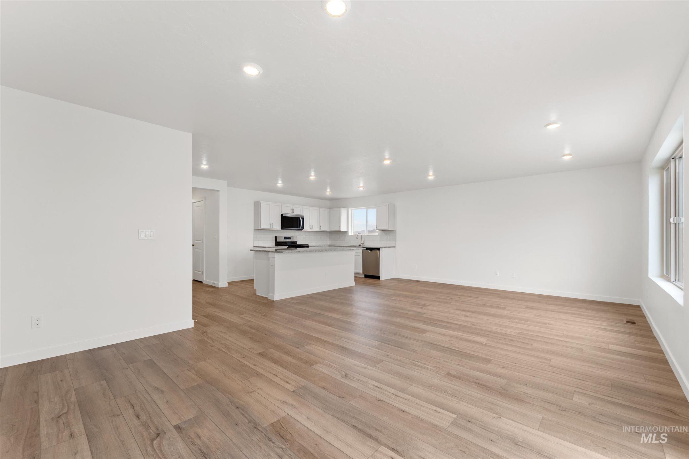 Unfurnished living room featuring light wood-type flooring and recessed lighting