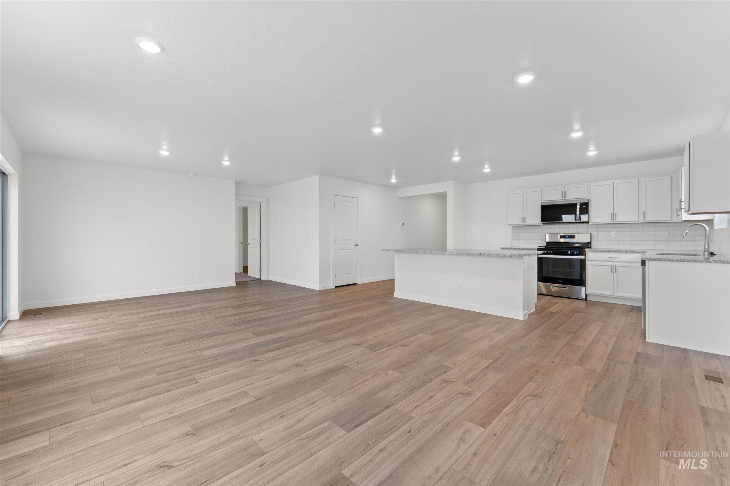 Unfurnished living room featuring light wood finished floors and recessed lighting