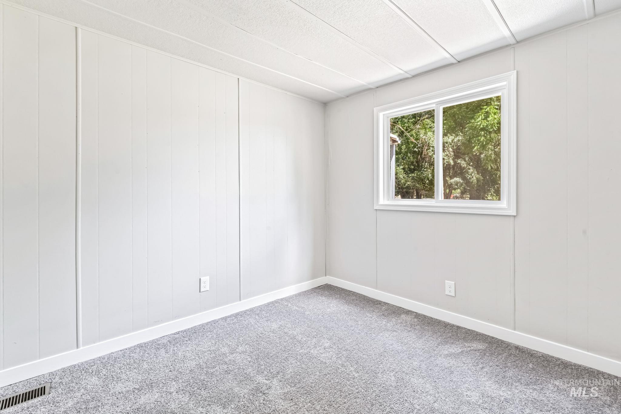 Carpeted spare room with baseboards