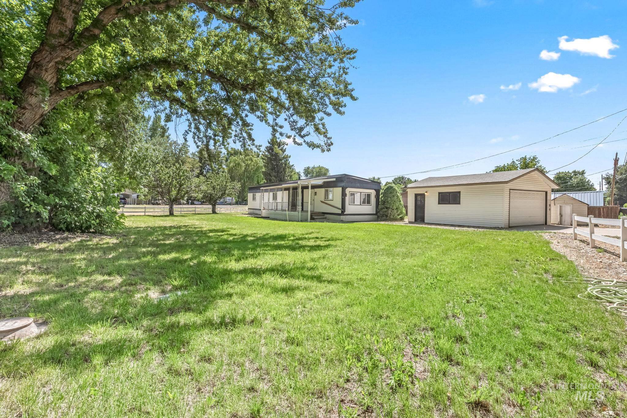 View of yard with an outbuilding, a garage, and a sunroom