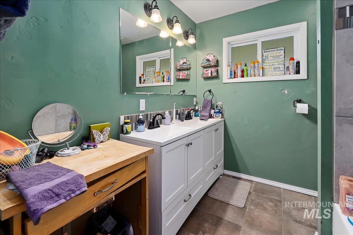 Full bath featuring vanity and baseboards