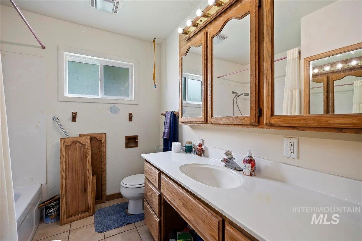 Bathroom with vanity, light tile patterned floors, and bathing tub / shower combination