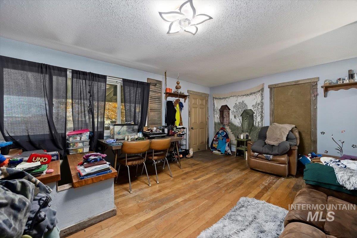 Living area featuring wood finished floors and a textured ceiling