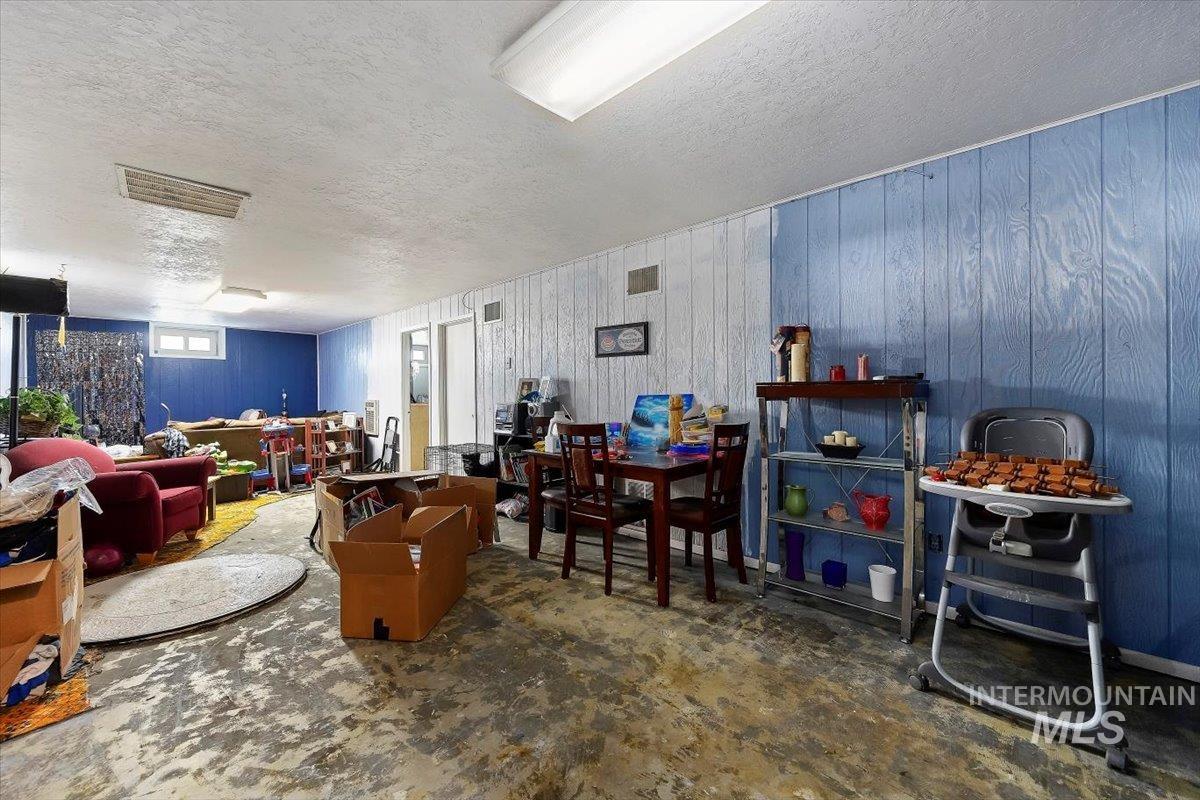 Playroom featuring a textured ceiling and wood walls