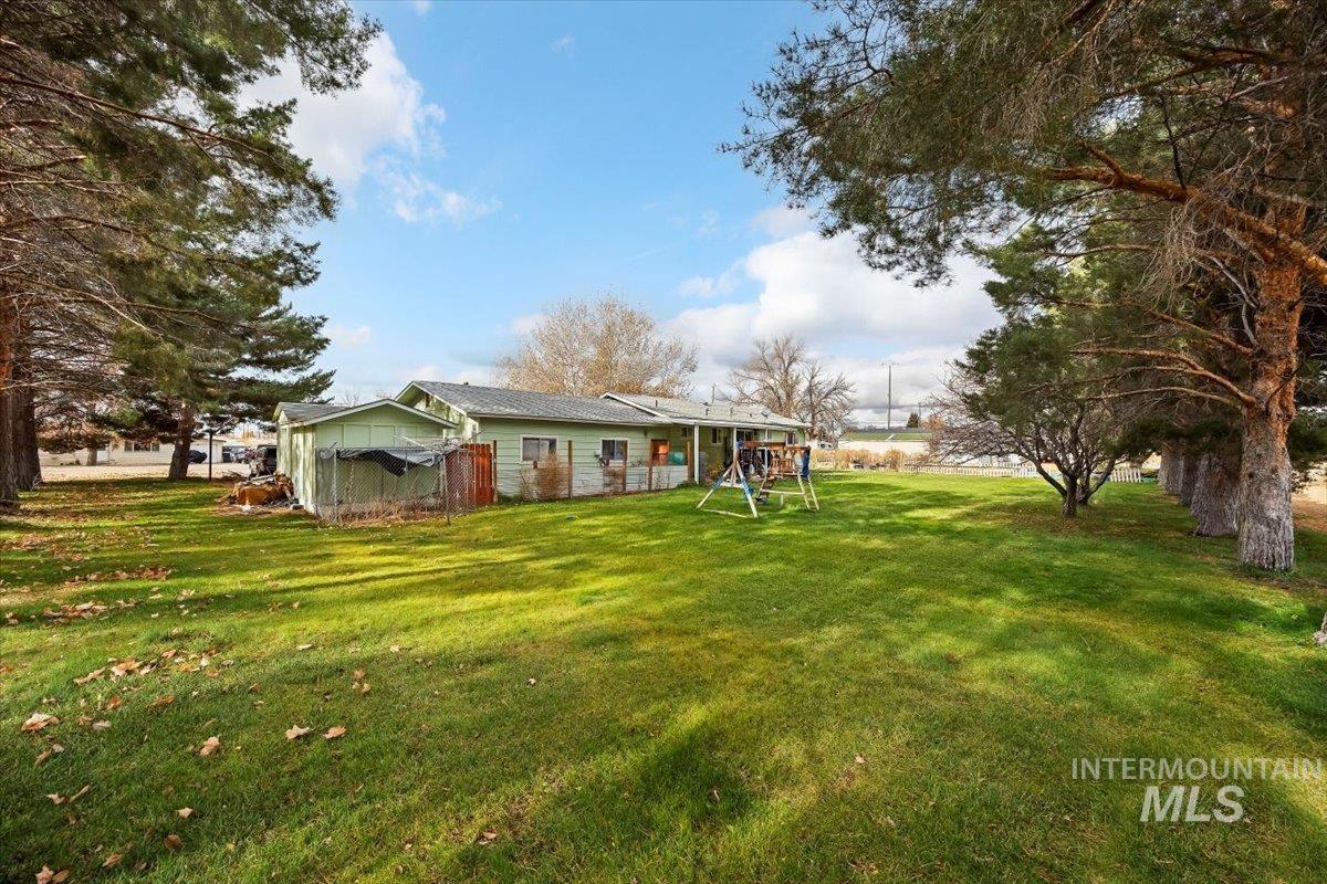 Rear view of property with a yard and a playground