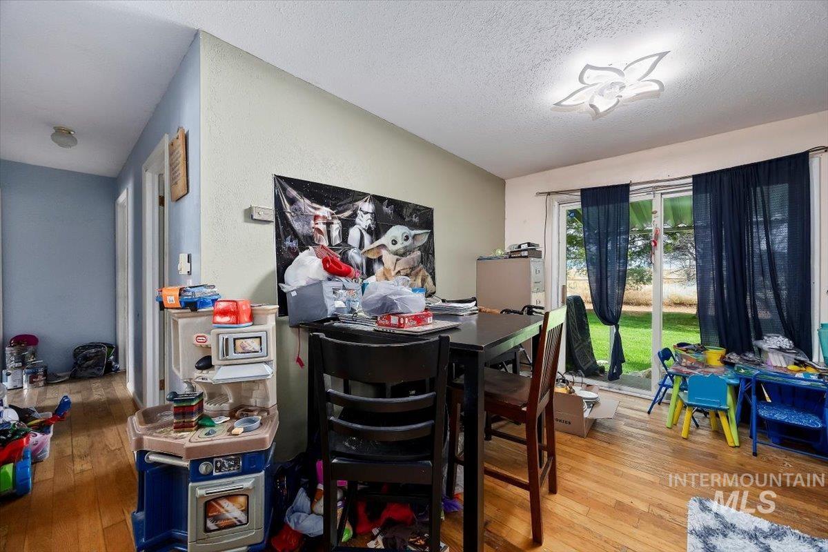 Dining room featuring light wood-style floors and a textured ceiling
