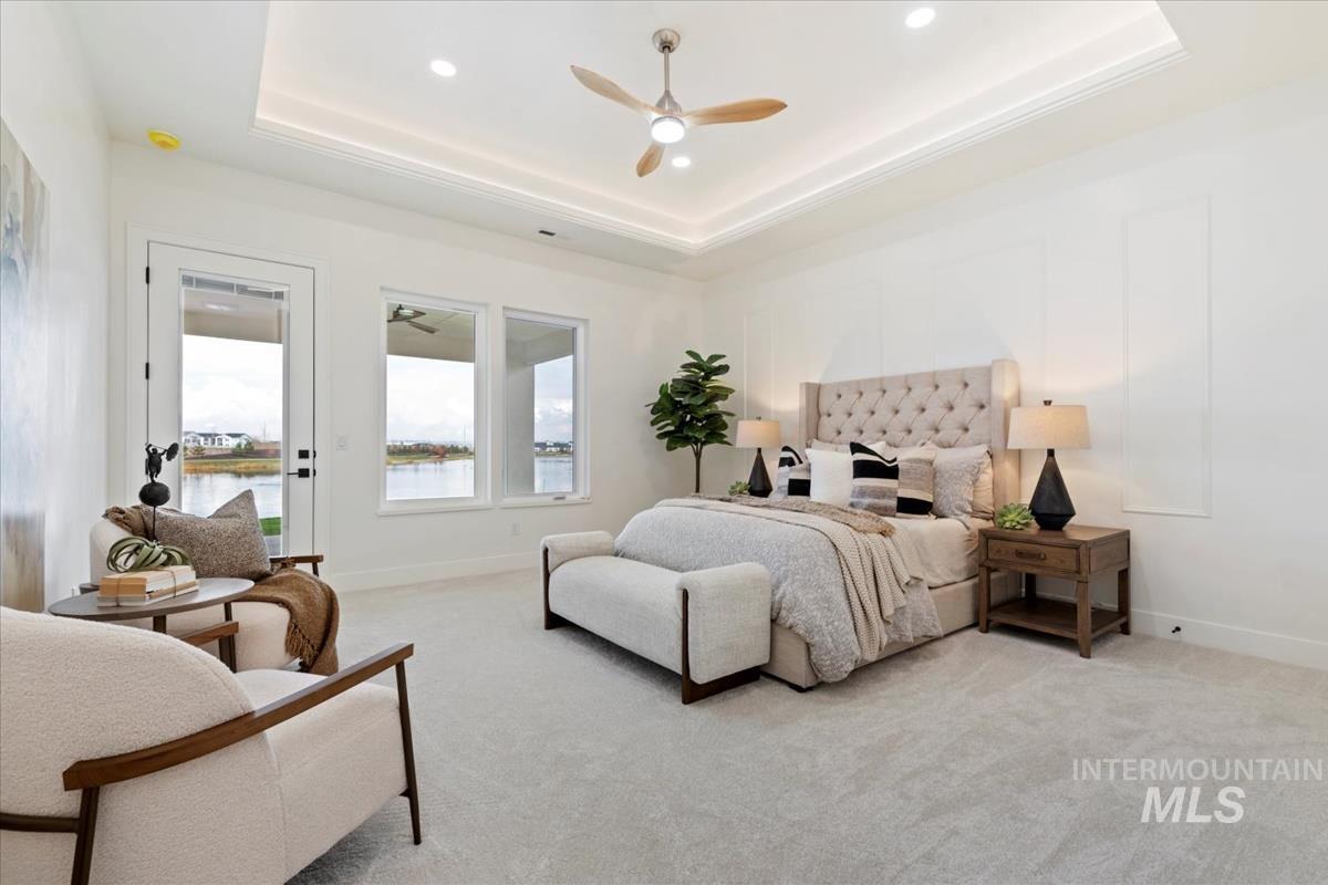 Bedroom featuring light colored carpet, a ceiling fan, access to outside, recessed lighting, and a raised ceiling